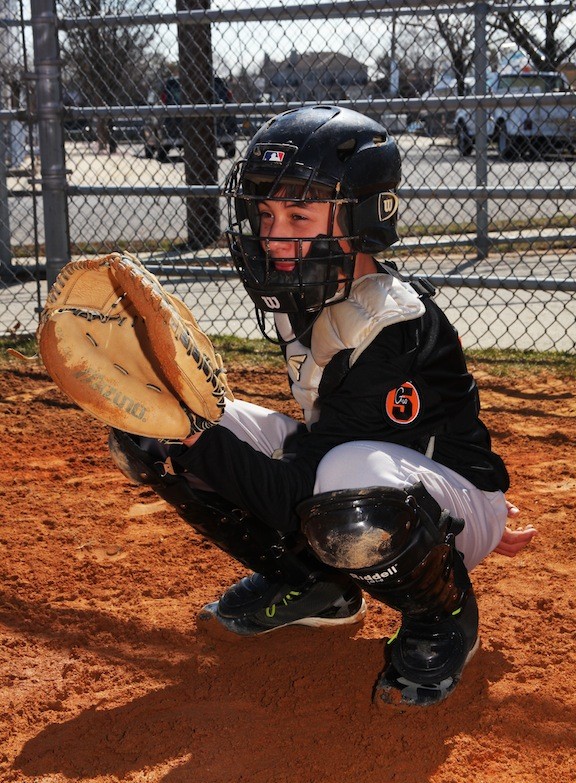12 year old Richie Madden plays catcher for the black team.
