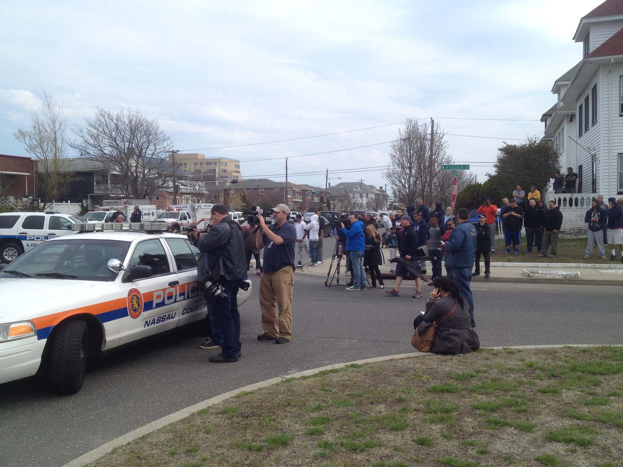 Laurelton Boulevard was teeming with news media on Tuesday, as residents and bystanders milled about near the scene.