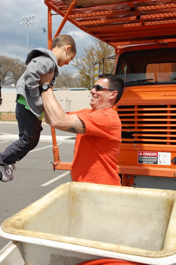 Joe Zuccaro of the village Highway Department gave Joseph Ortiz, 5, a boost into the bucket of a tree-trimming truck.