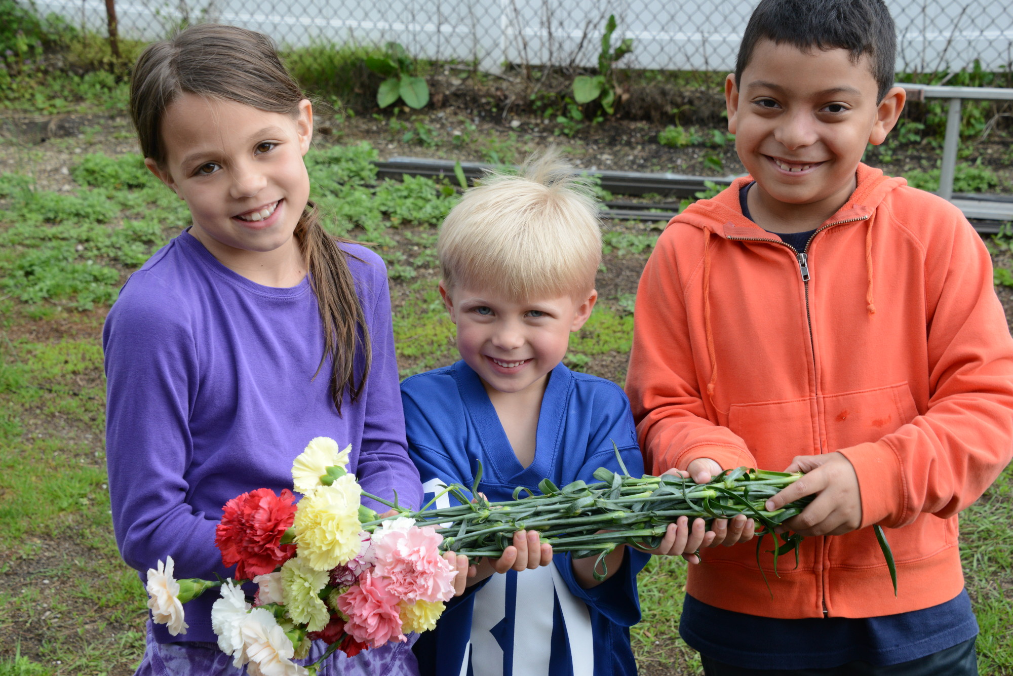 Caroline lozado, 8, Declan Lozado 6,  and Justinn Iturrino, 8, collected flowers for their moms at South Nassau Christian Church’s Mother’s Day dinner on May 10.