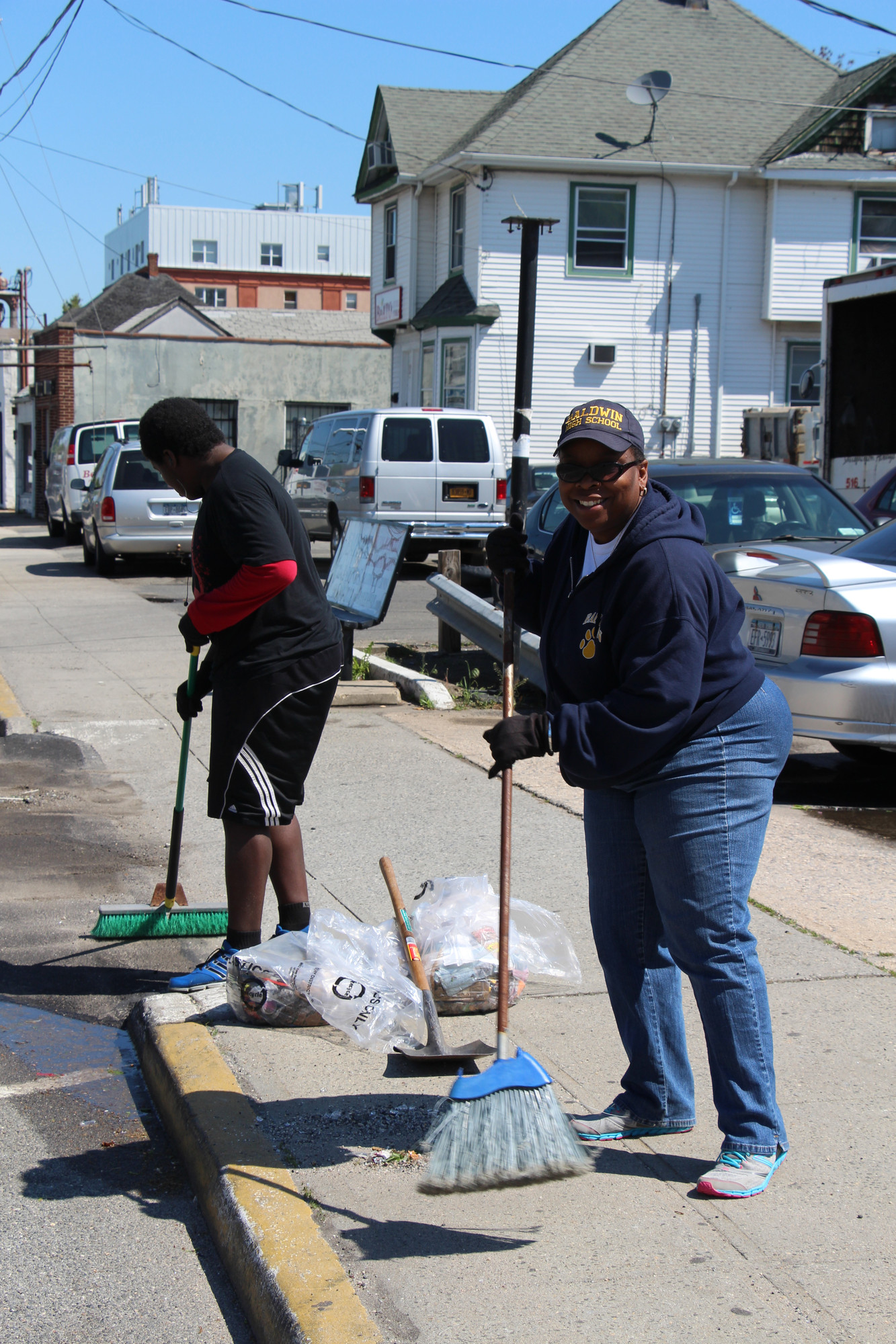 Karyn Reid and her son Avery swept and cleaned up debris on Grand Avenue, in preparation for the Memorial Day Parade the following weekend.