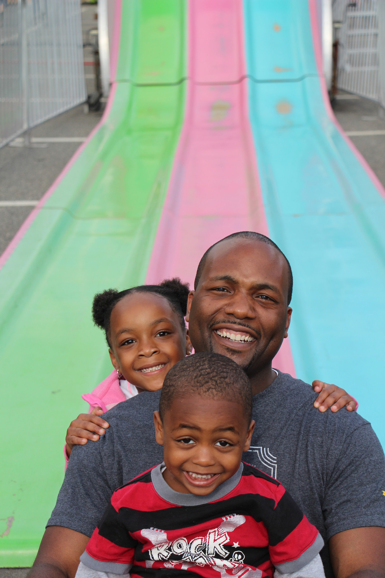 Ibrahim Jackson went down the slide with his two kids,  Morgan, 5, and Jared, 3, at the Baldwin Chamber of Commerce carnival, which took place May 29 ­— June 1 at the Long Island Rail Road station.
