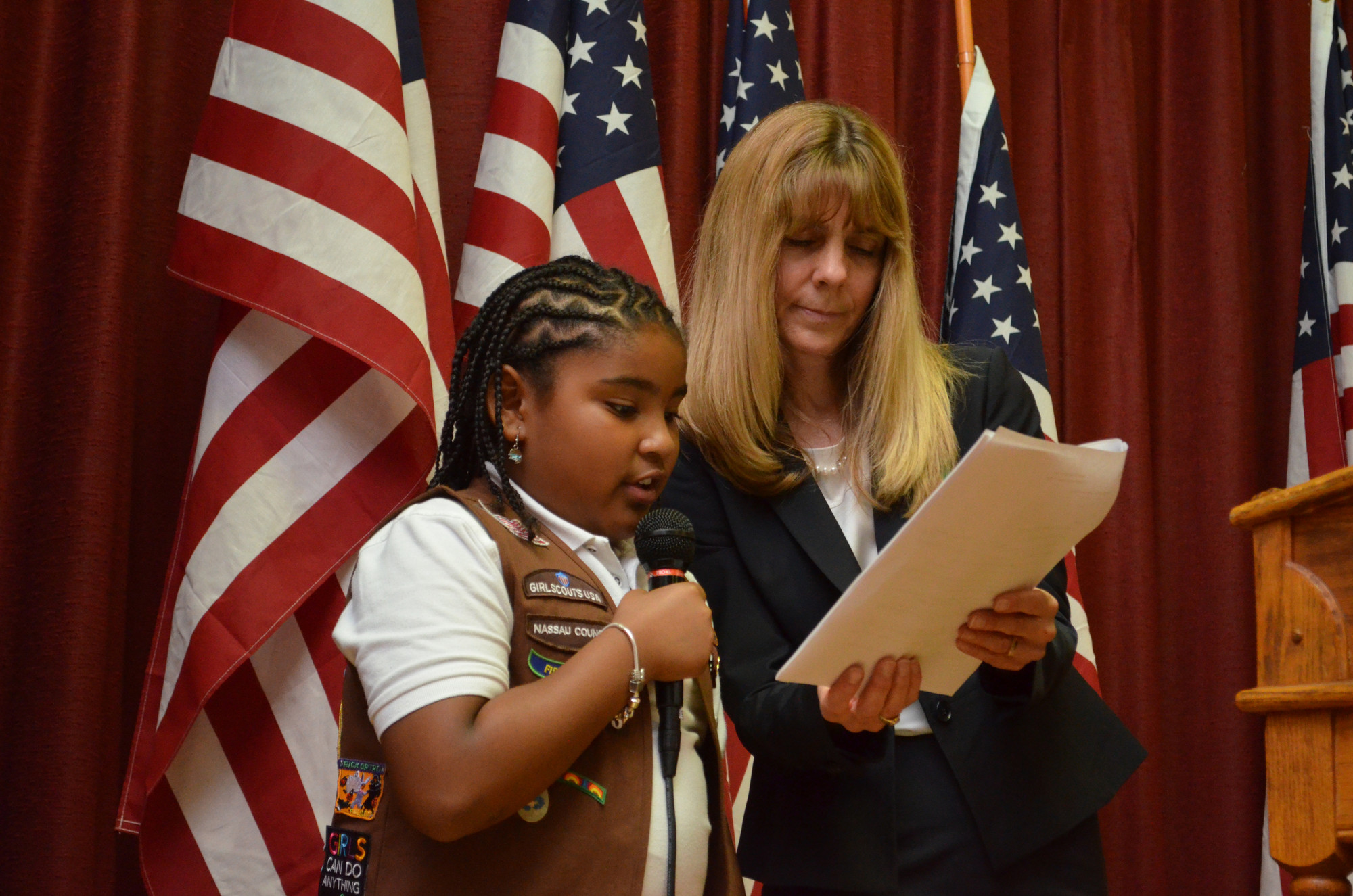 Jaiden Powell got some help from Troop Leader Dawn Samuel in addressing her fellow Girl Scouts.
