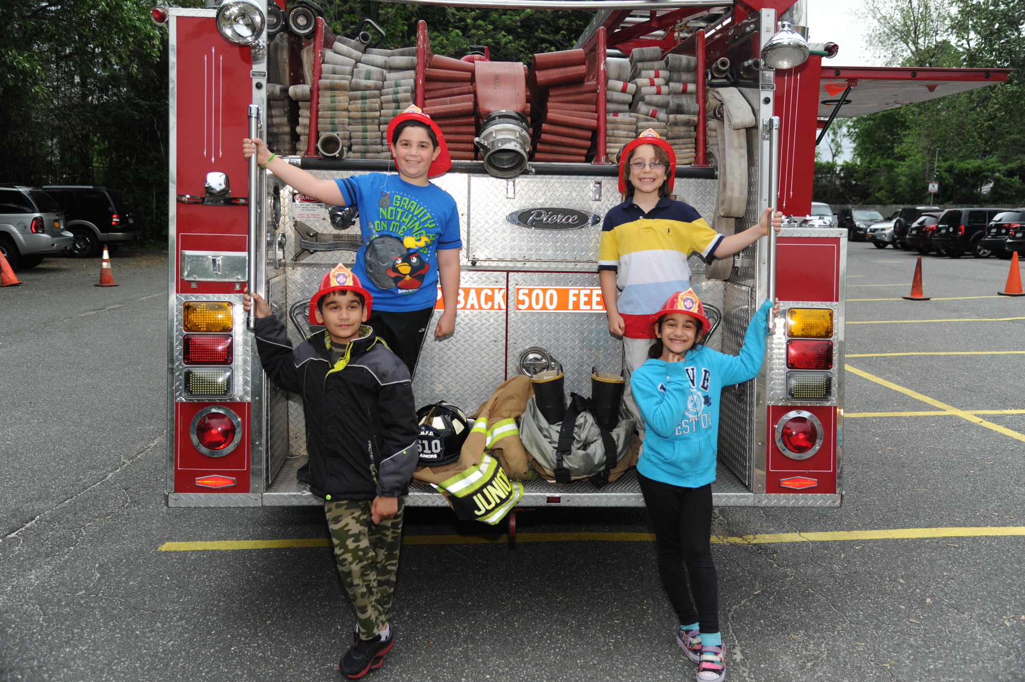 Ben Krieger, 7, Samuel Feldman, 8, Davis Schiller, 9, and Miriam Feldman, 8, looked the part of East Meadow firefighters.
