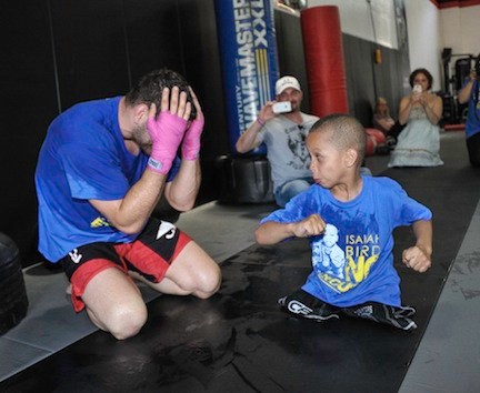 UFC Champion, left, sparred with 6-year-old Isaiah Bird, a member of the Long Beach Gladiators wrestling team, who was born with a defect that left him without legs. Weidman held a fundraiser last Sunday for Bird and his family, who are currently living in a Freeport shelter.