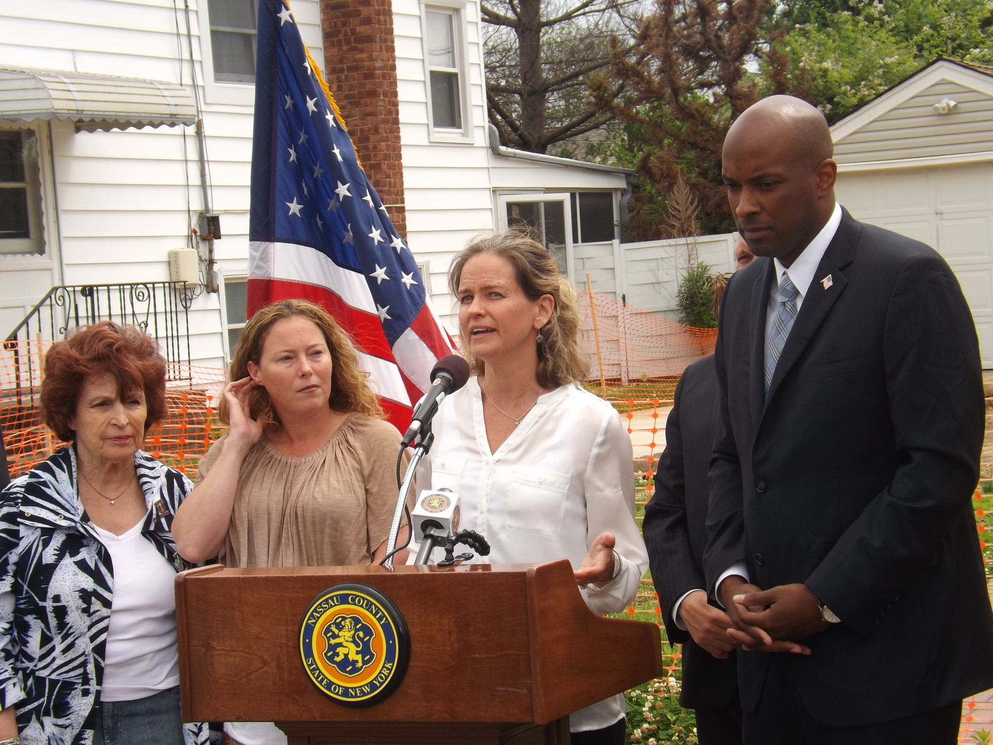 Legislator Laura Curran , second from right and her colleagues in the County Legislature, including Norma Gonsalves, far left, and Kevan Abrahams, said that re-funding the program was the right move at a press conference last week in front of the property of East Rockaway resident Theresa Gaffney, second from left.