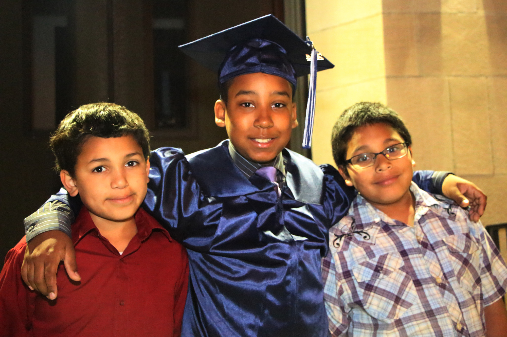 Graduate Michael Valenzuela  ,13, with his cousins, Adrian Rivera,10, and Jonathan Rivera, 9yrs, following the ceremony on June 12.