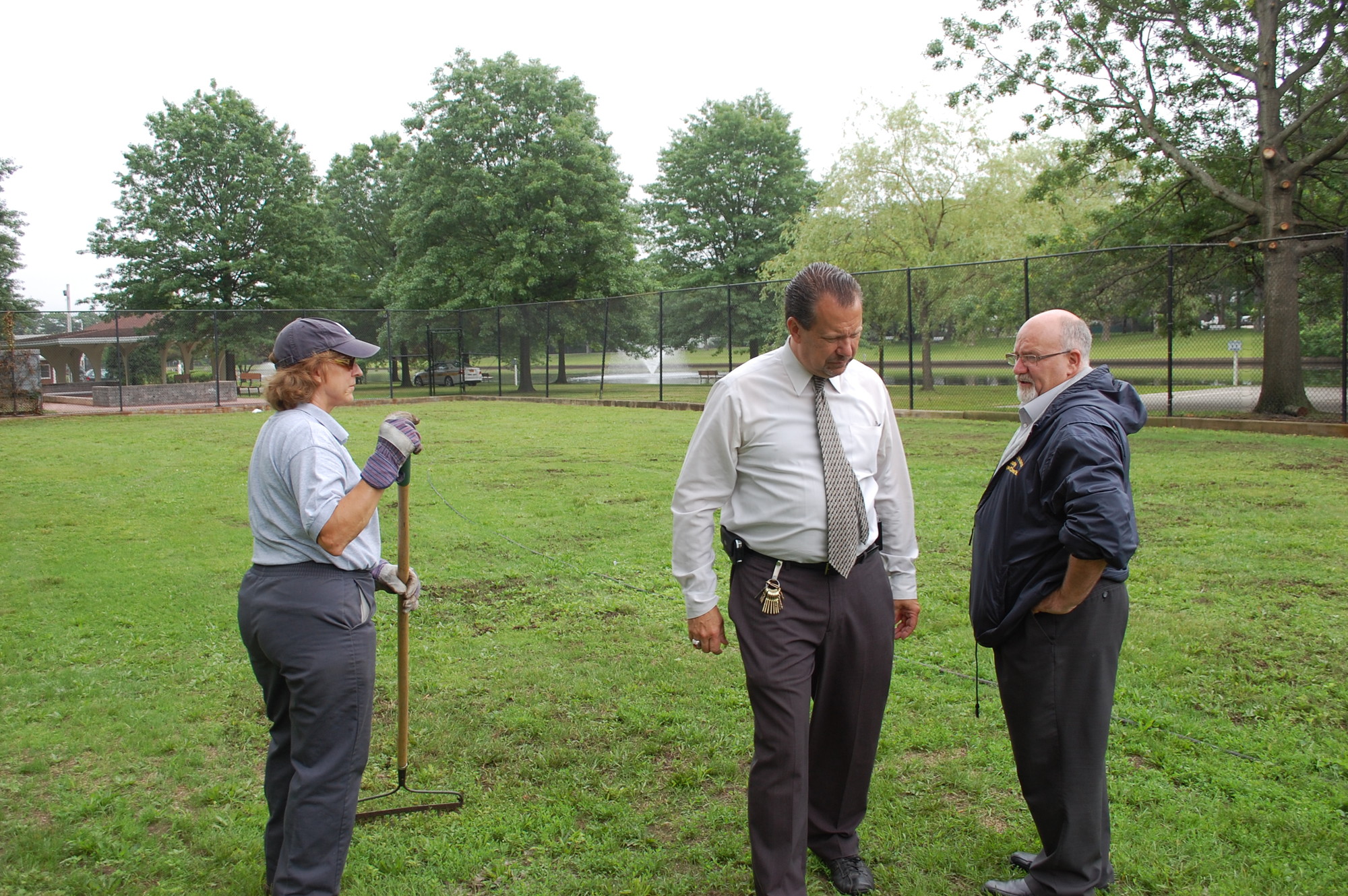 Lorraine Werbeck of the Parks Department gets an area ready at Hendrickson Park for Monday movie nights as Mayor Ed Fare and Deputy Village Clerk Richard DeAngelis look over the progress.