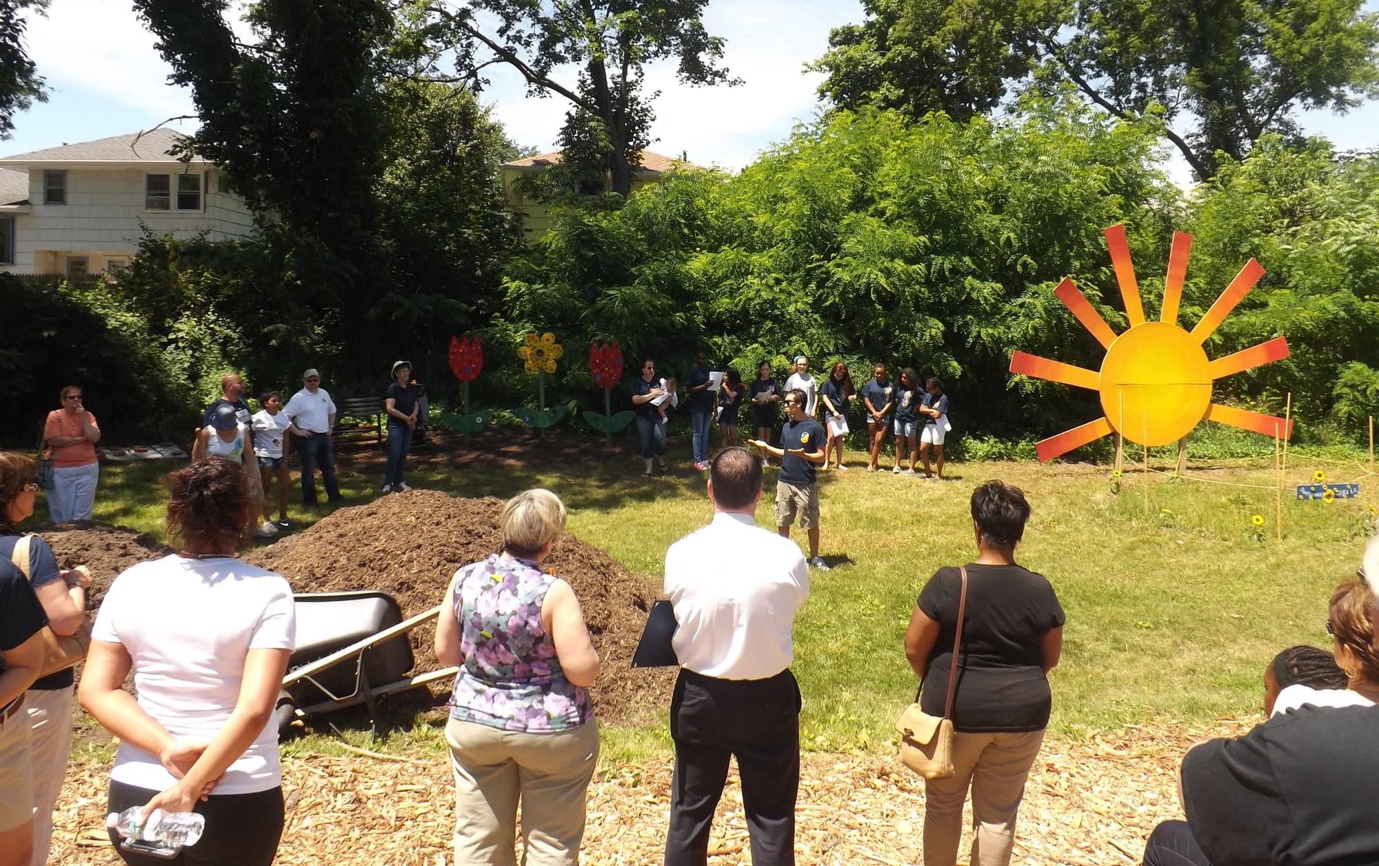 The Baldwin Civic Association hosted a ceremony on June 21 to open its new community garden behind the Baldwin Historical Society Museum, off Grand Ave. BCA President David Viana, center, welcomed residents and thanked those who helped create the garden.
