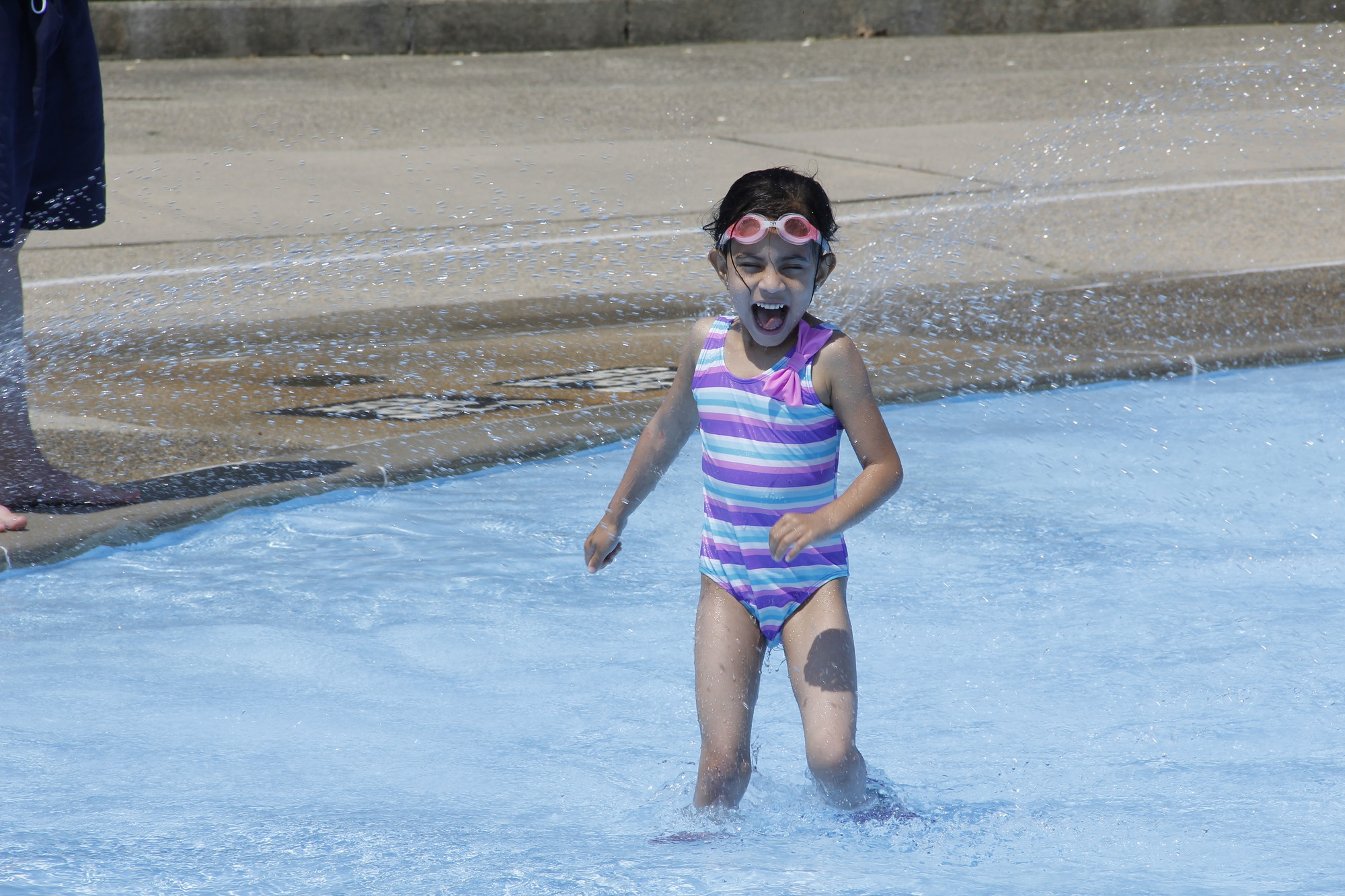 Natalie Suriel, 5, had fun running through the spray at the pool.