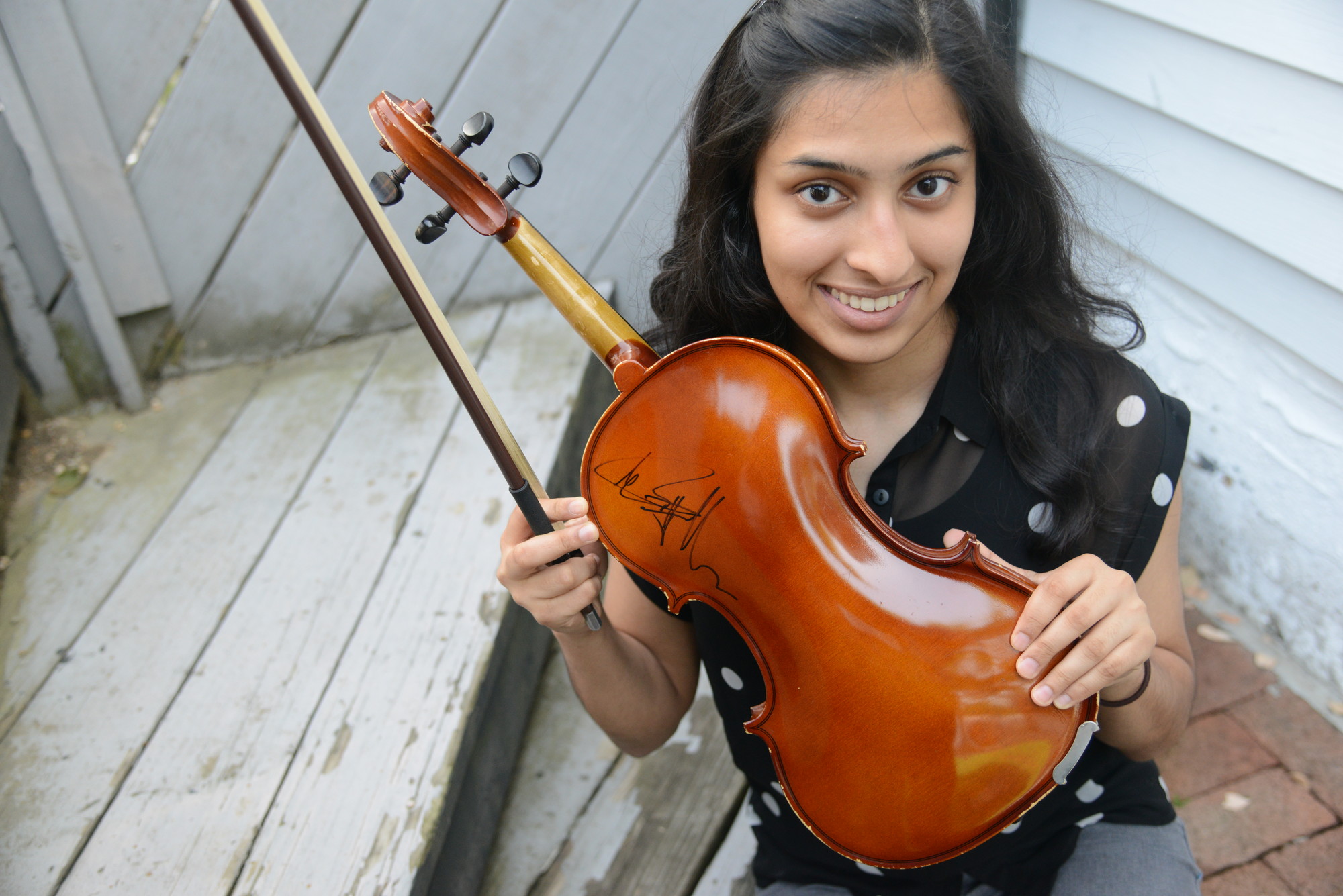 The sisters played at the NYCB Theatre in Westbury last December with the Piano Guys, a musical duo that combines classical and pop music. The group autographed Binita’s violin.