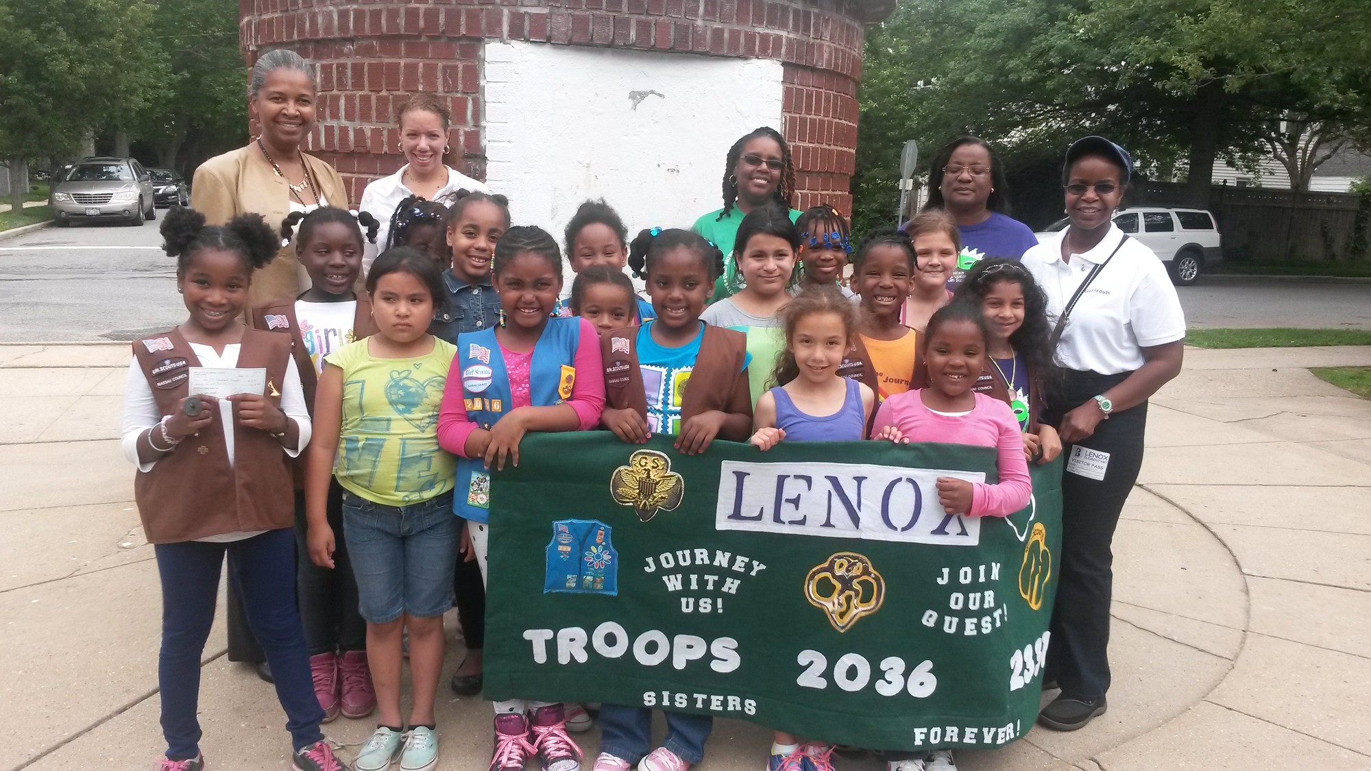Girl Scout Troop 2036 donated $75 to Troop 2331’s project to brighten up the ticket booth at Lenox Elementary School. Troop 2036 members and leaders posed with Lenox Principal Bernice Acevedo, left, in the spring.