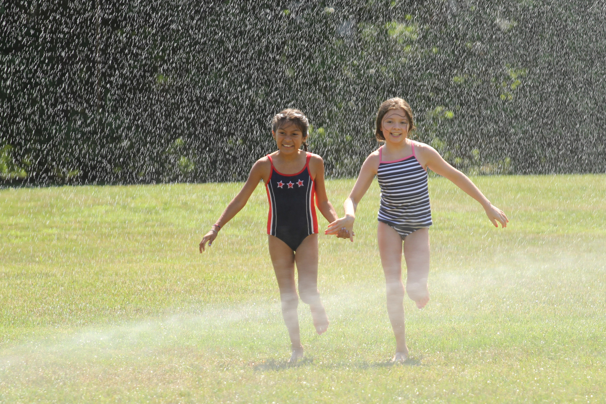 Ana Patchke and Kaitlin Sullivan ran through sprinklers at the Rec Center last Friday to cool off on a hot summer day.