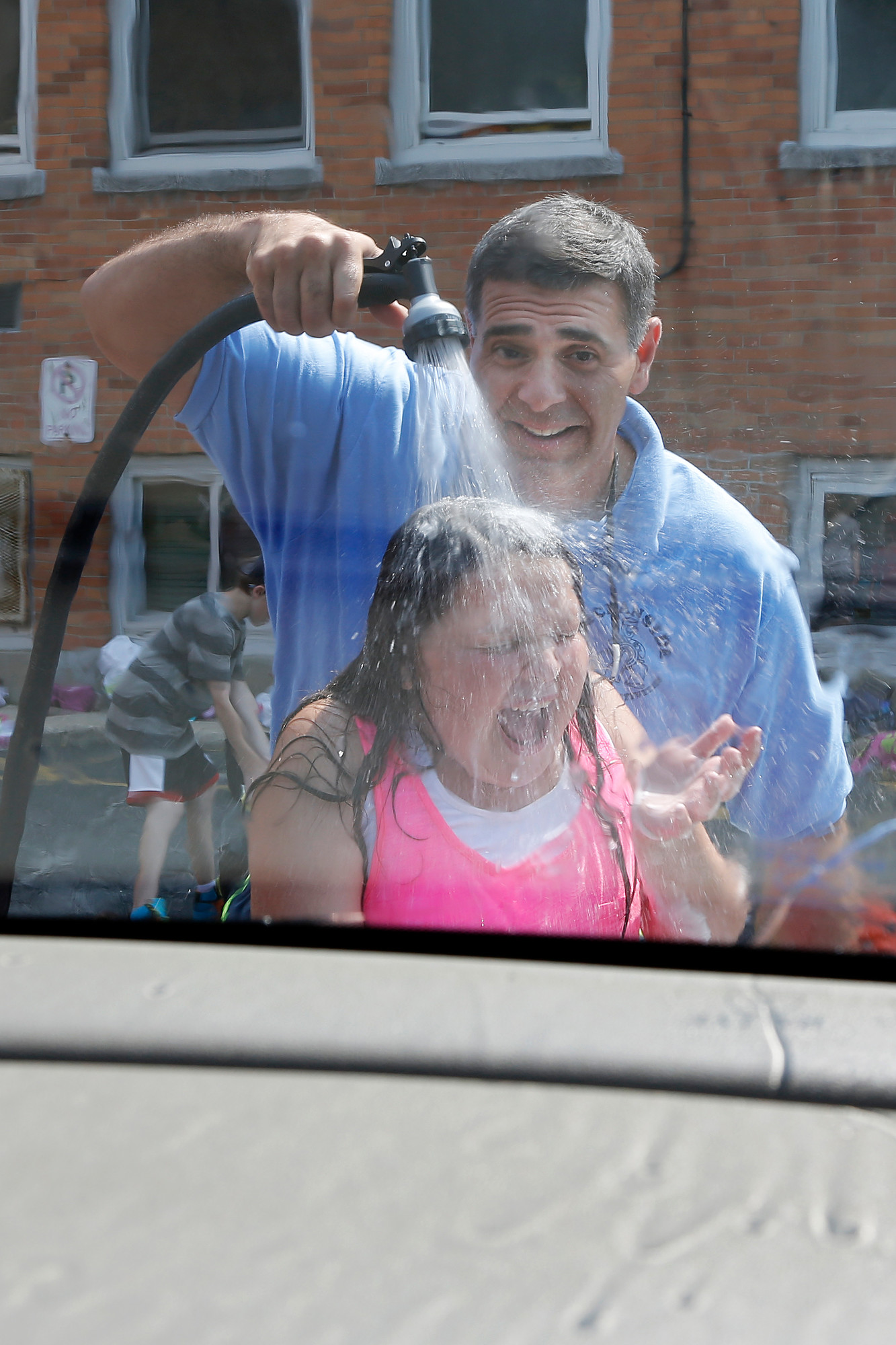 Head Counselor Chris Marzo rinsed off soon-to-be fourth grader Karley Albano.