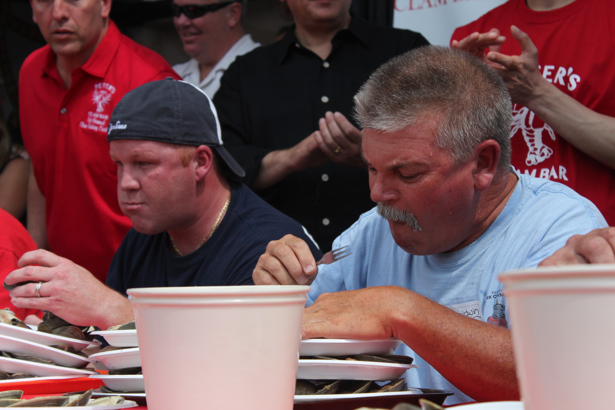 Bob McKenna, left, and Chris Neville worked their way through plates of clams to make a good showing for the Baldwin Fire Department in the first Clam Eating Contest at Peter’s Clam Bar in Island Park last Sunday.
