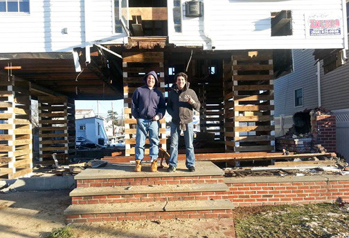 Homeowner Carl Zipperlen, left, with friend Brian Barry in front of Zipperlen’s newly-raised home last December.