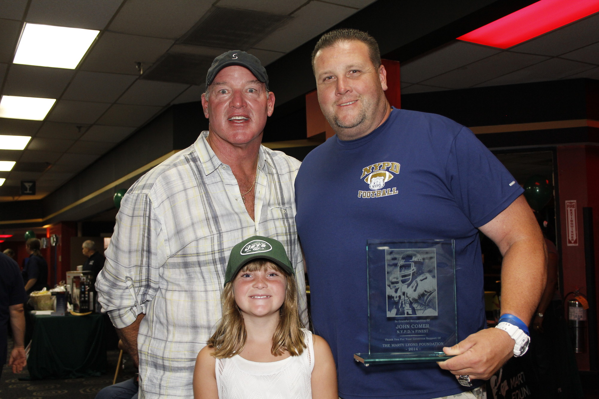 John Comer was honored by Marty Lyons with a plaque that read "In grateful recognition of John Comer, N.Y.P.D.'s Finest. Thank you for your generouos support of the Marty Lyons Foundation, 2014" They are pictured here with Johns daughter Makayla, 8.