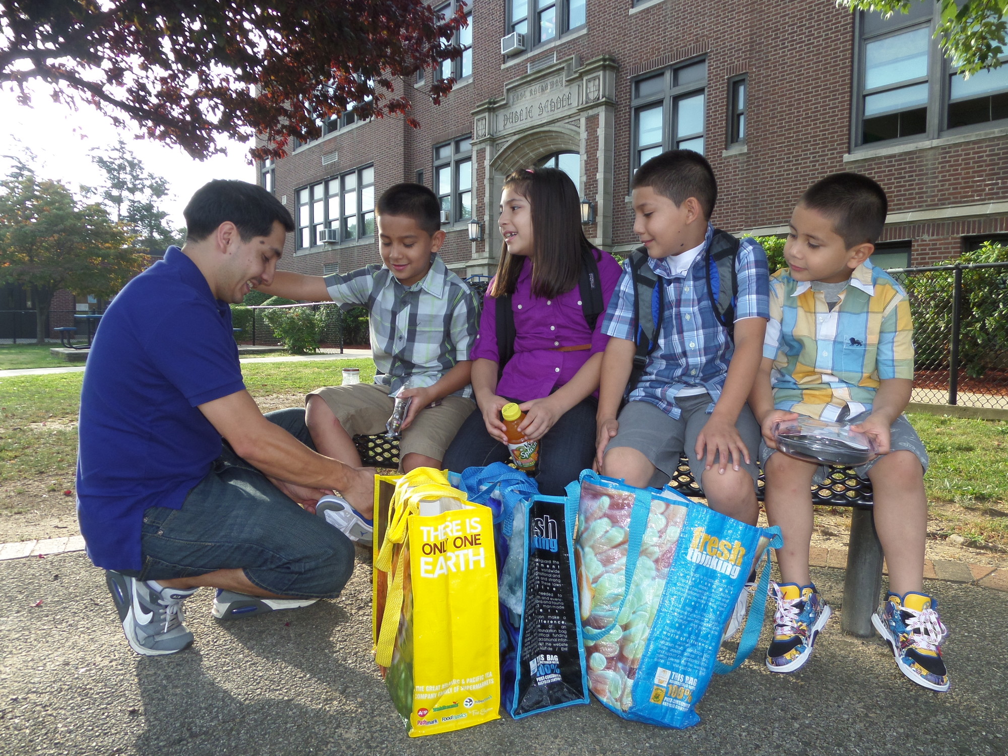 Andres Vanegas did a final check of his children's outfits after they arrived at Centre Avenue Elementary in East Rockaway for their first day of school on Tuesday. Seated from left were Dylan, Chloe, Elias, and Fabian