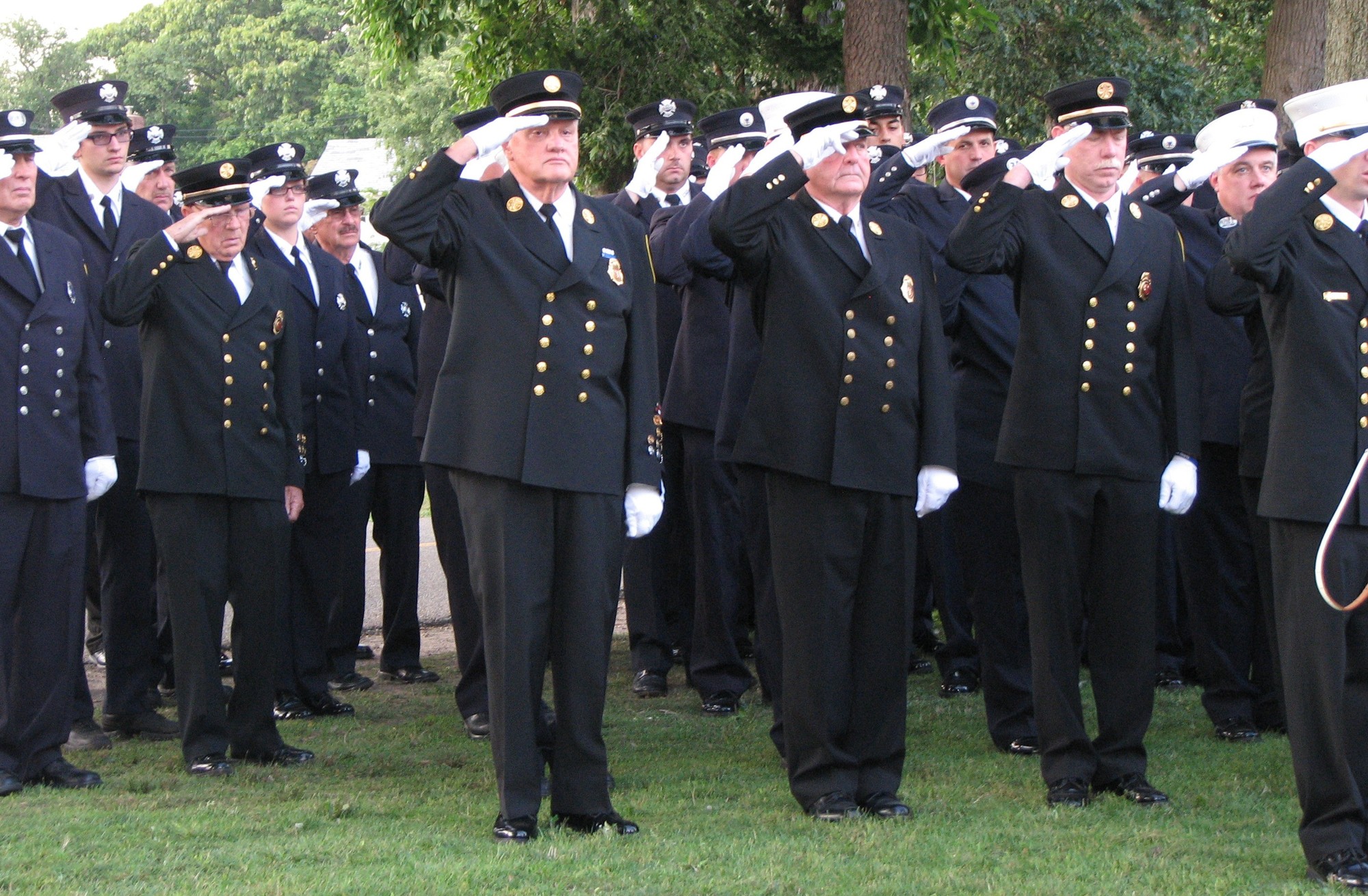 Members of the Valley Stream Fire Department salute during the ceremony