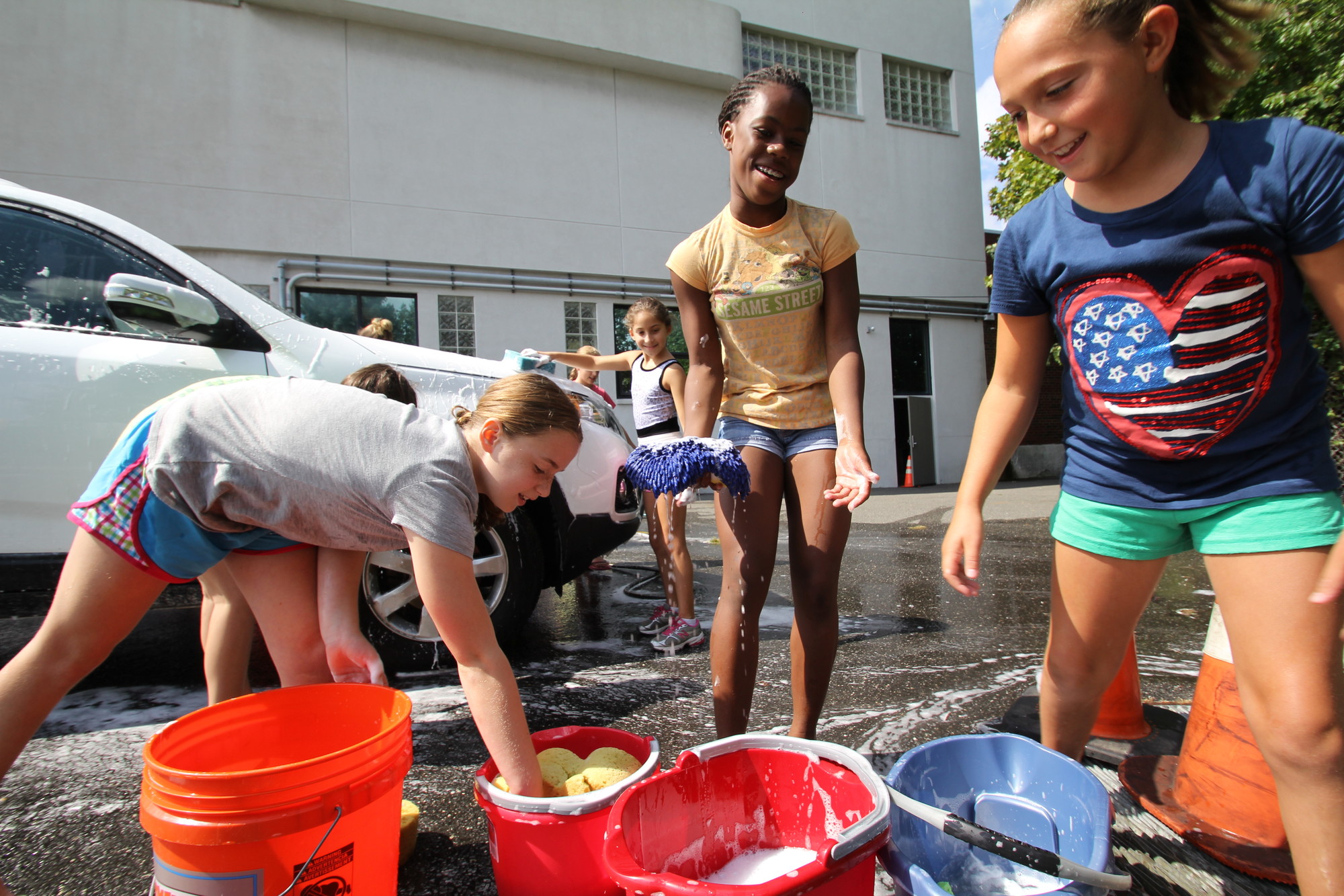 Erin Agoglia, left, Alexa Virgo and Sophie Greenberg, members of the Rec Center’s Ultimate Gymnastics team soaped up their sponges during the Gymnastics Car Wash at the Rec Center last weekend.