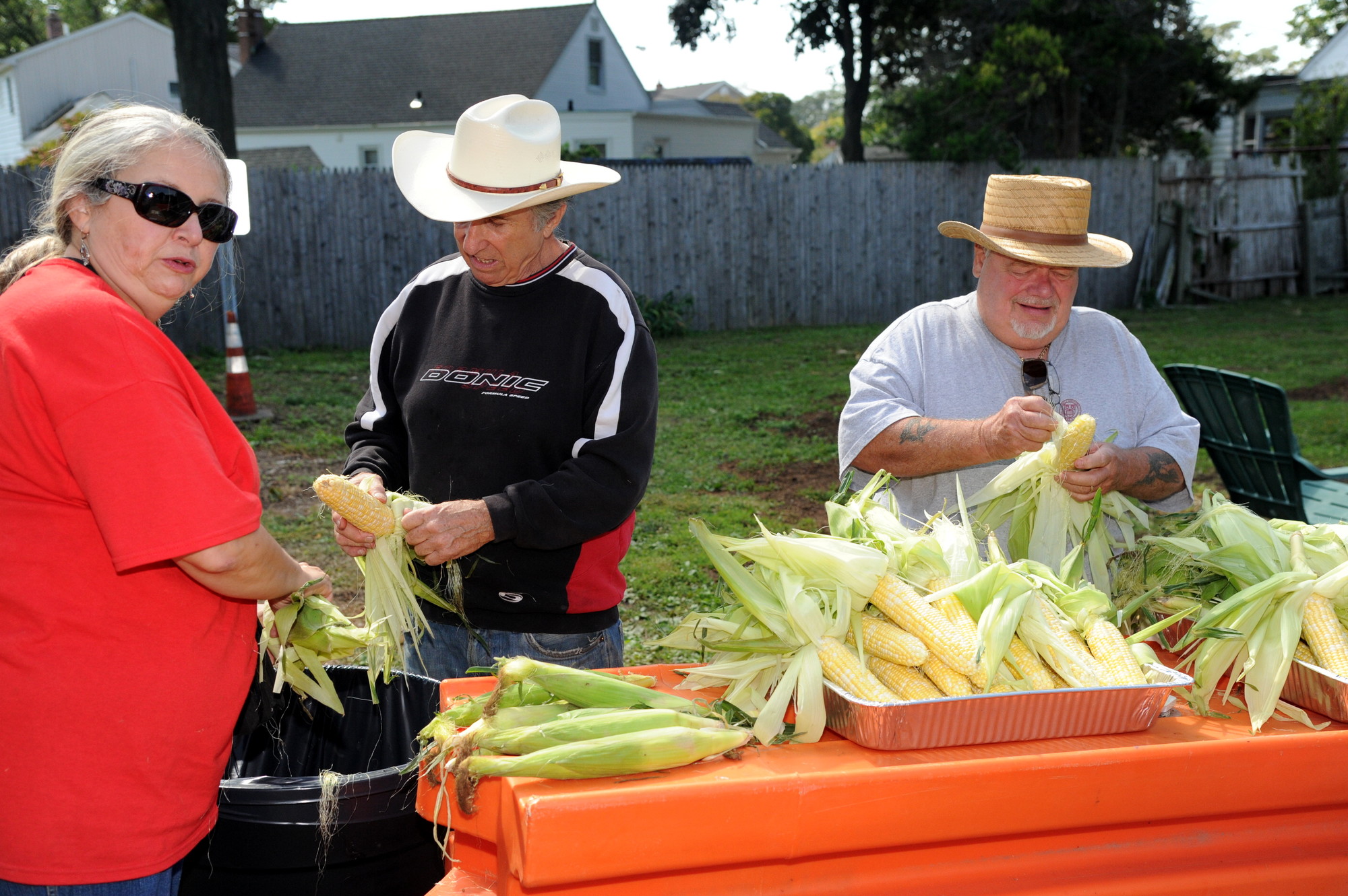 Lisa Perez, Bruce Kozlowsky and John Styles spent the afternoon shucking corn last Saturday.