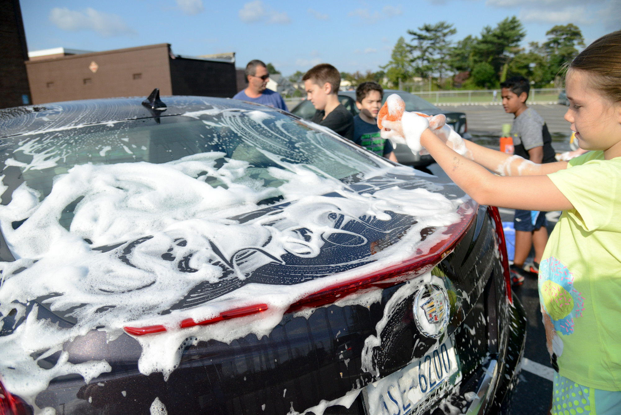 Jenna Cozier washed the first car—but not before writing a message in the suds— at the School No. 5 car wash.