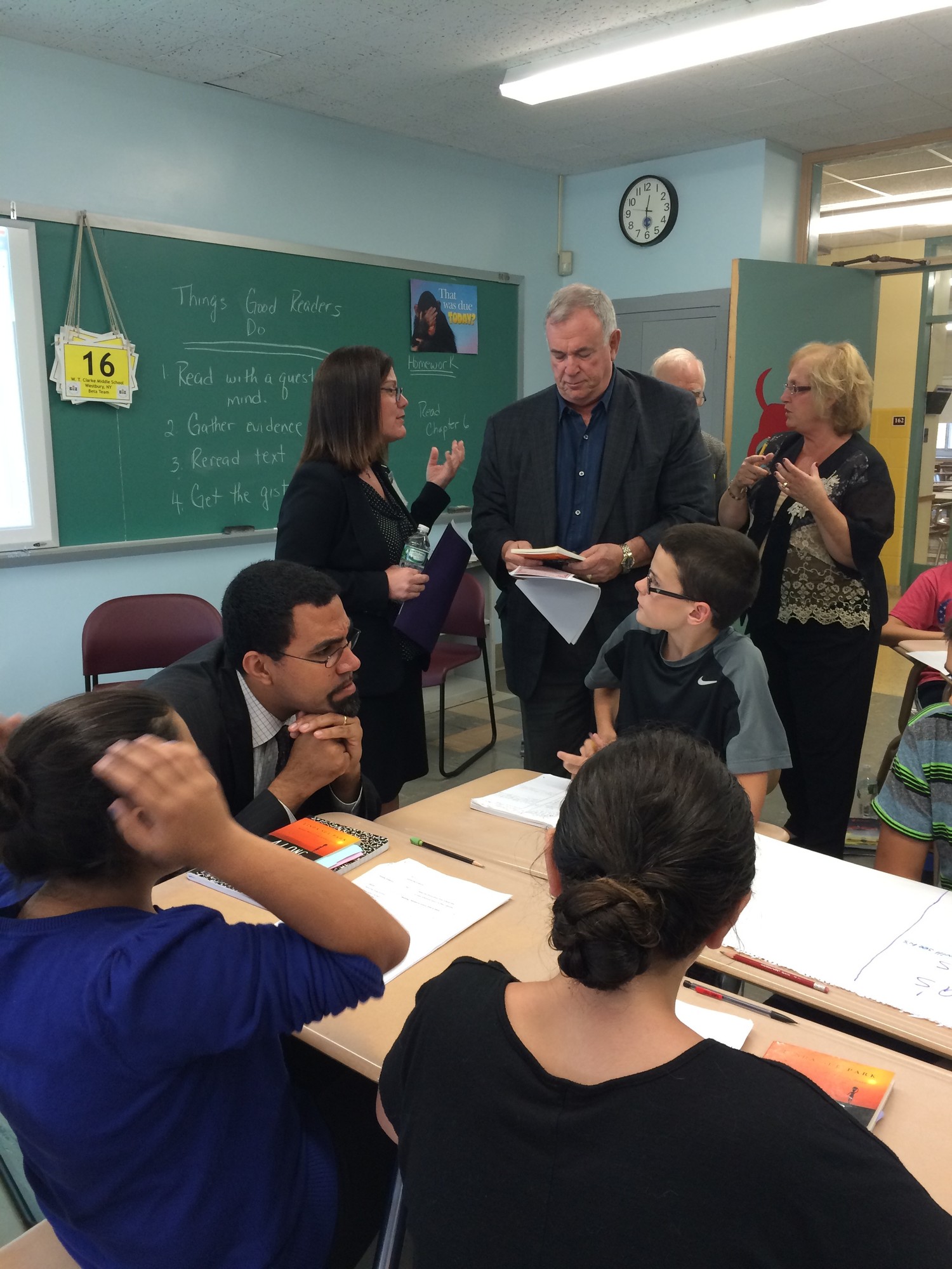 Dr. John King Jr., seated at left, the state education commissioner, spoke with students at W.T. Clarke Middle School on Oct. 2, while Roger Tilles, top middle, Nassau’s representative on the Board of Regents, chatted with Principal Stacy Breslin.