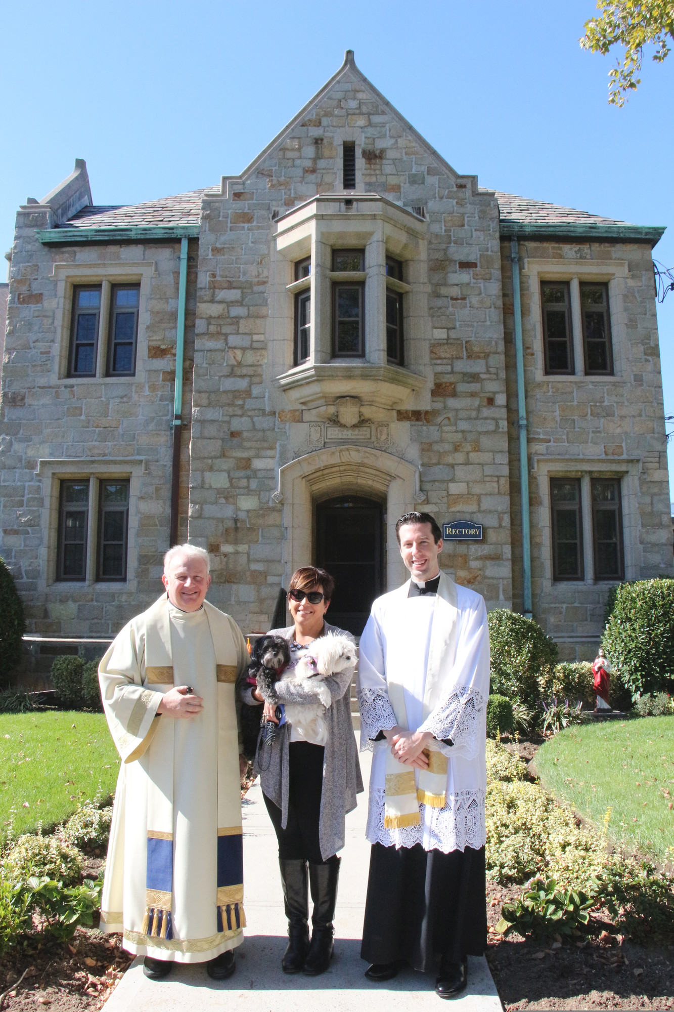 Diane Donlon brought her dogs Daisy and Darbi to be blessed at St. Christophers by Msgr. Steven Camp, left, and the Rev. Brandon O’Brien.