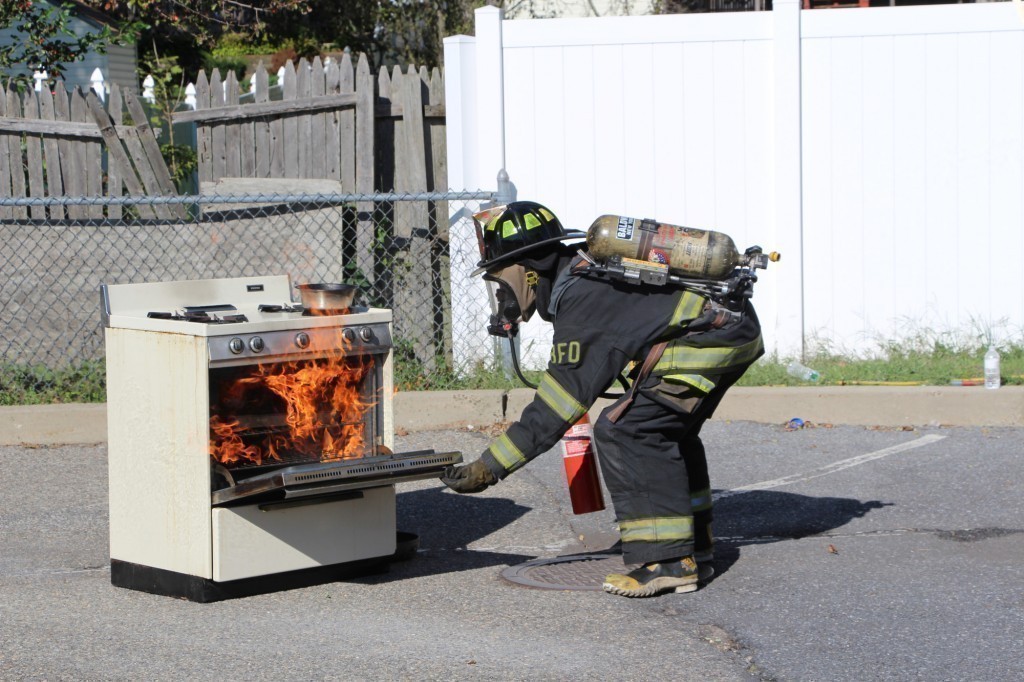 Firefighter Paul Ennis demonstrated how to put out a stove fire during the Baldwin Fire Department’s Fire Prevention Open House last Sunday.