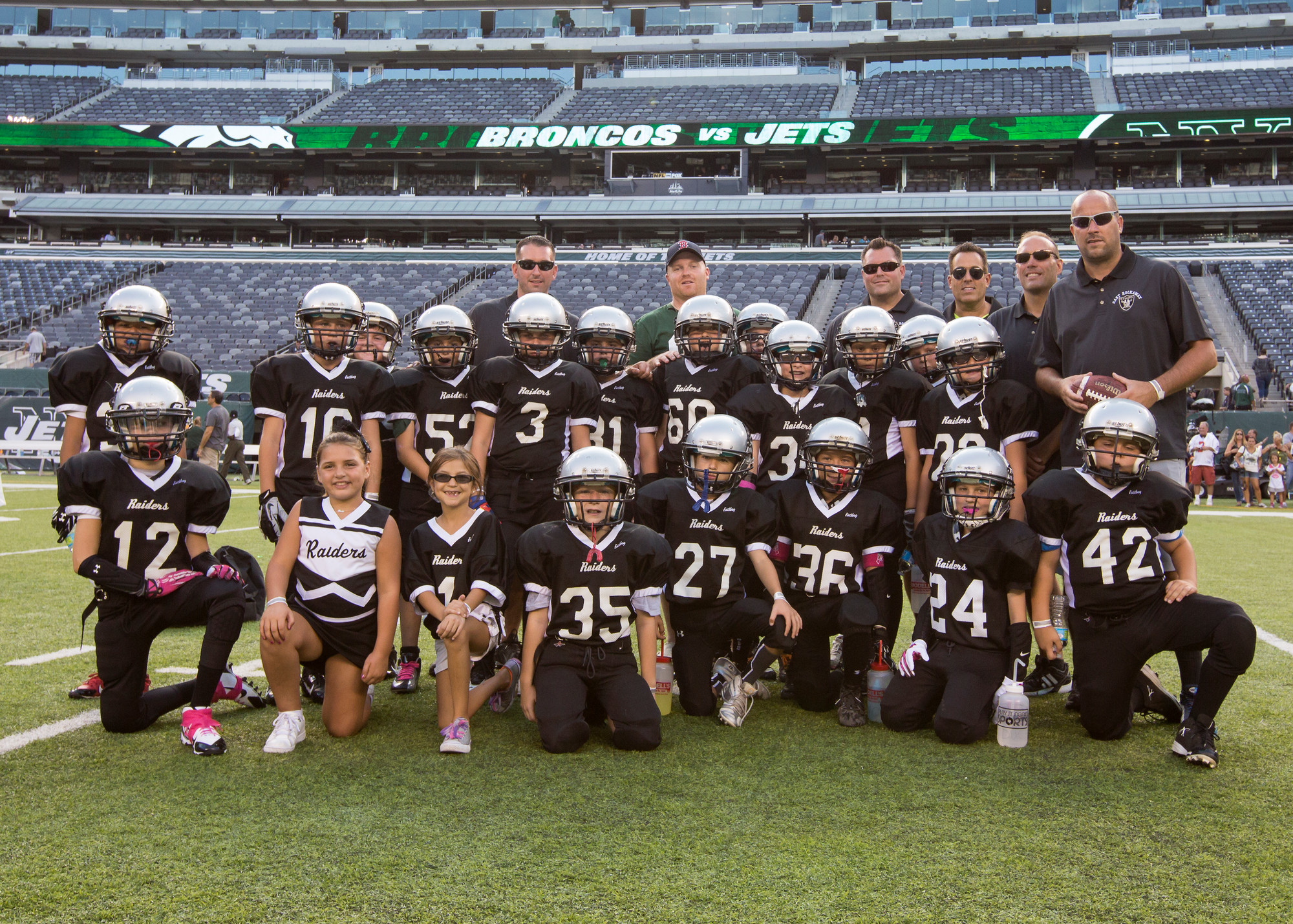 The raiders, cheerleaders and coaches paused for a team photo after their scrimmage at MetLife Stadium.