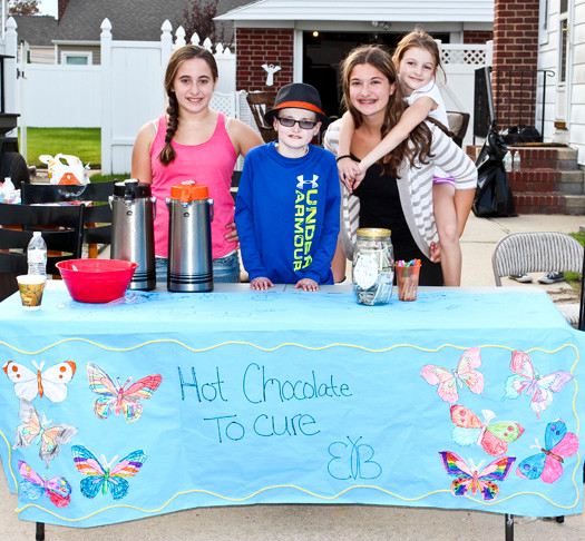 Alison and Emily Carman, sisters at W.T. Clarke Middle School, sold hot chocolate last Saturday in front of their East Meadow home to raise money to find a cure for epidermolysis bullosa. Their friend Robbie Twible, center, an eighth-grader at Clarke, has E.B. Perched atop Emily was Robbie’s 7-year-old sister, Allison.