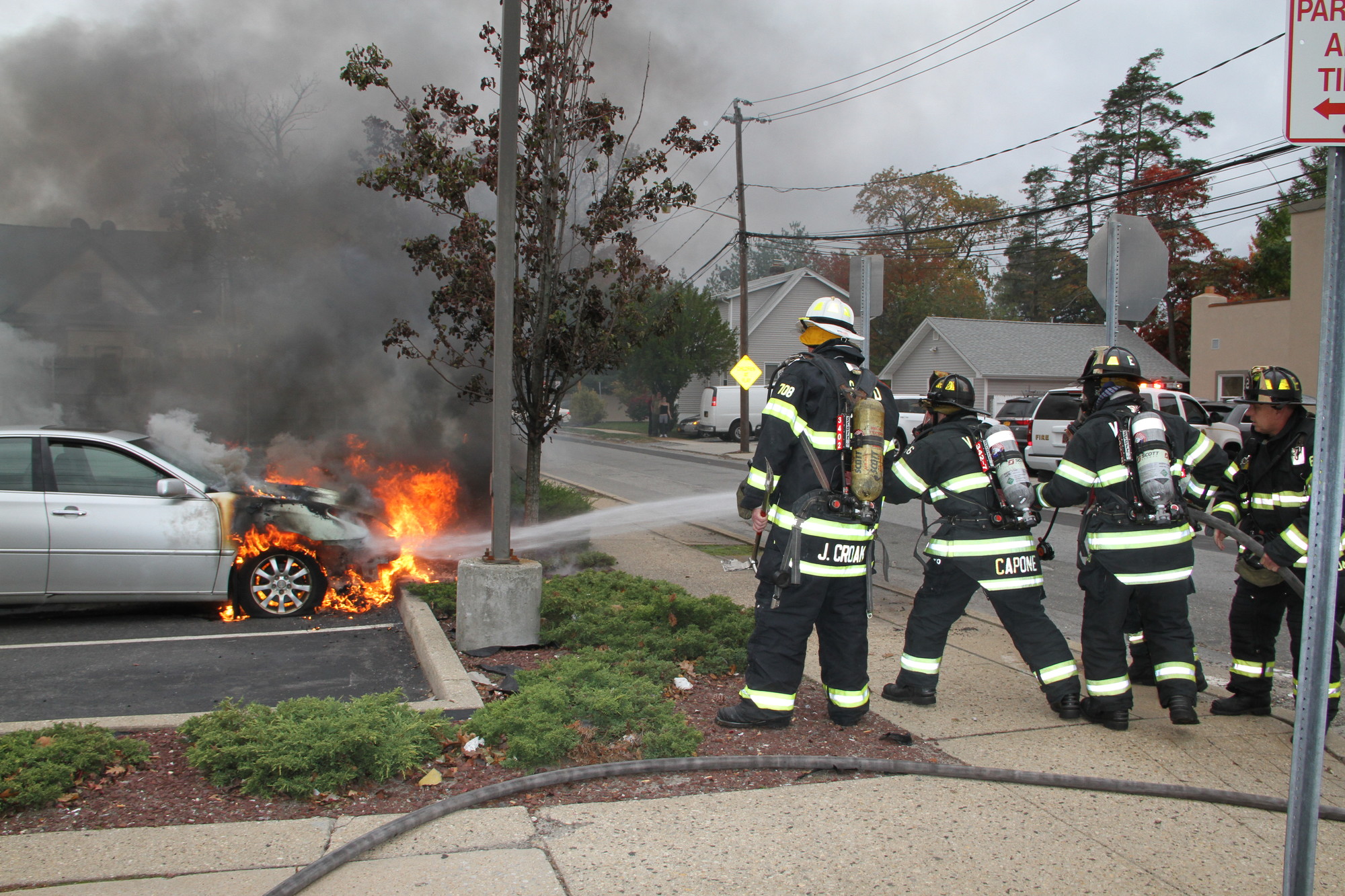 Firefighters extinguished a blaze that broke out under the hood of a car parked in the lot of NEFCU
