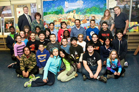 About 25 students showed off the finished mural, depicting the Nassau Pops Symphony Orchestra in performance. In the top row is Woodland Principal James Lethbridge, County Legislator Norma Gonsalves, Nassau Pops cellist Lougene Kennedy and art teacher John Healy. Seated, in the center, is Pops conductor Louis Panacciulli.