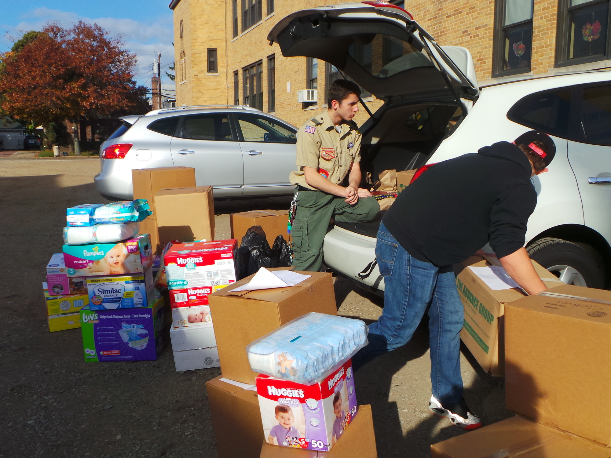 Brendan Warner, an Eagle Scout candidate in Troop 24 in Malverne, left, packs a car full of donations destined for the Haven House, a homeless shelter in Brentwood.