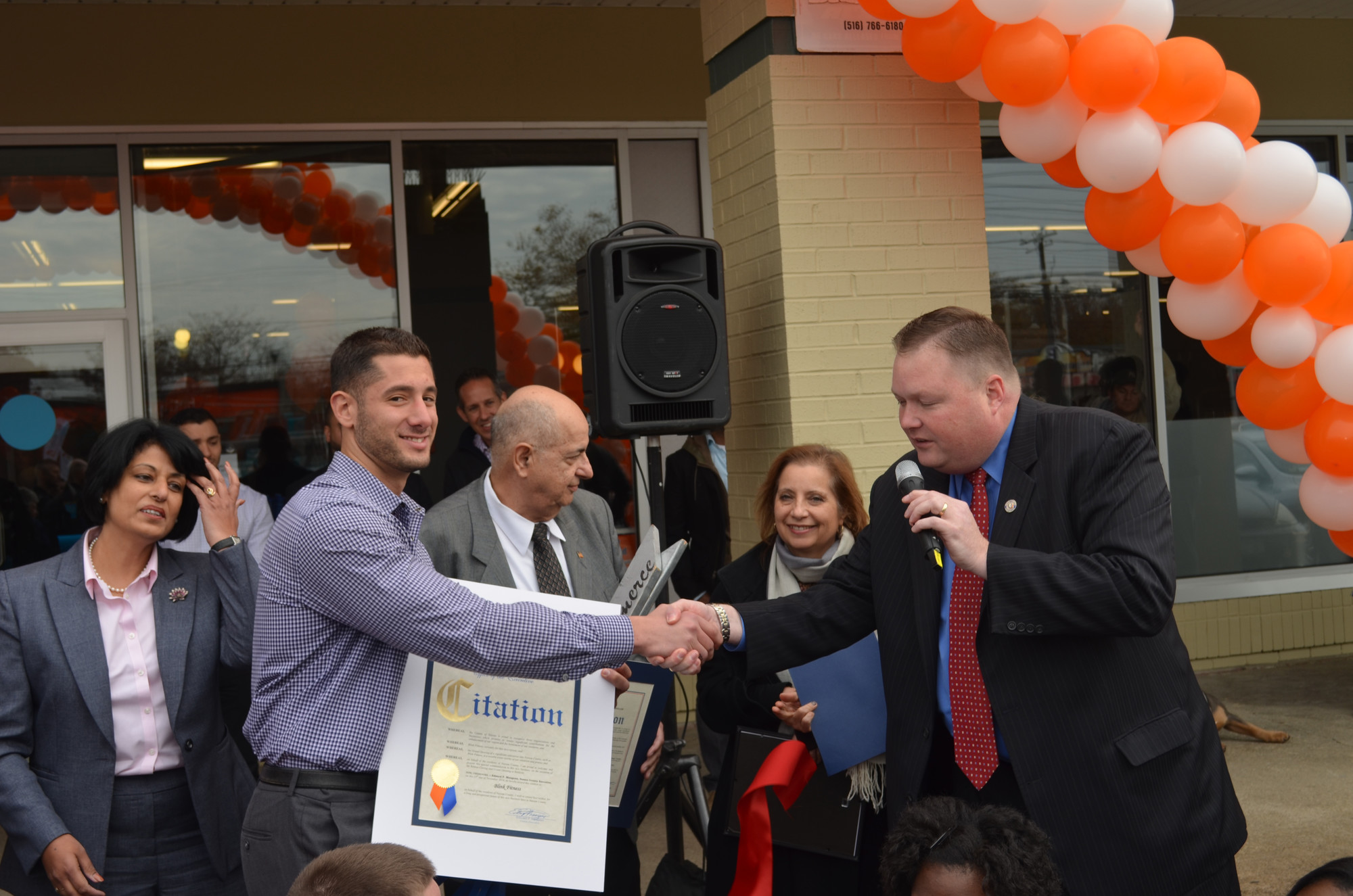 Stephen Catanzaro, left, Blink’s Baldwin club manager, shook hands with local politicans and community leaders, including Chris Brown from County Executive Ed Mangano’s office, during the grand opening ceremony.