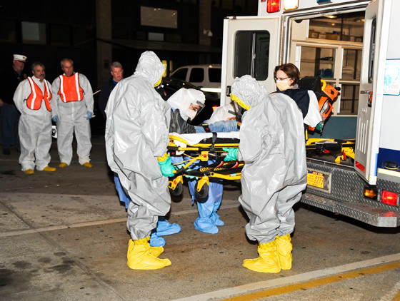 NUMC staff donning hazardous materials suits removed the patient from a fire truck outside the emergency ward.