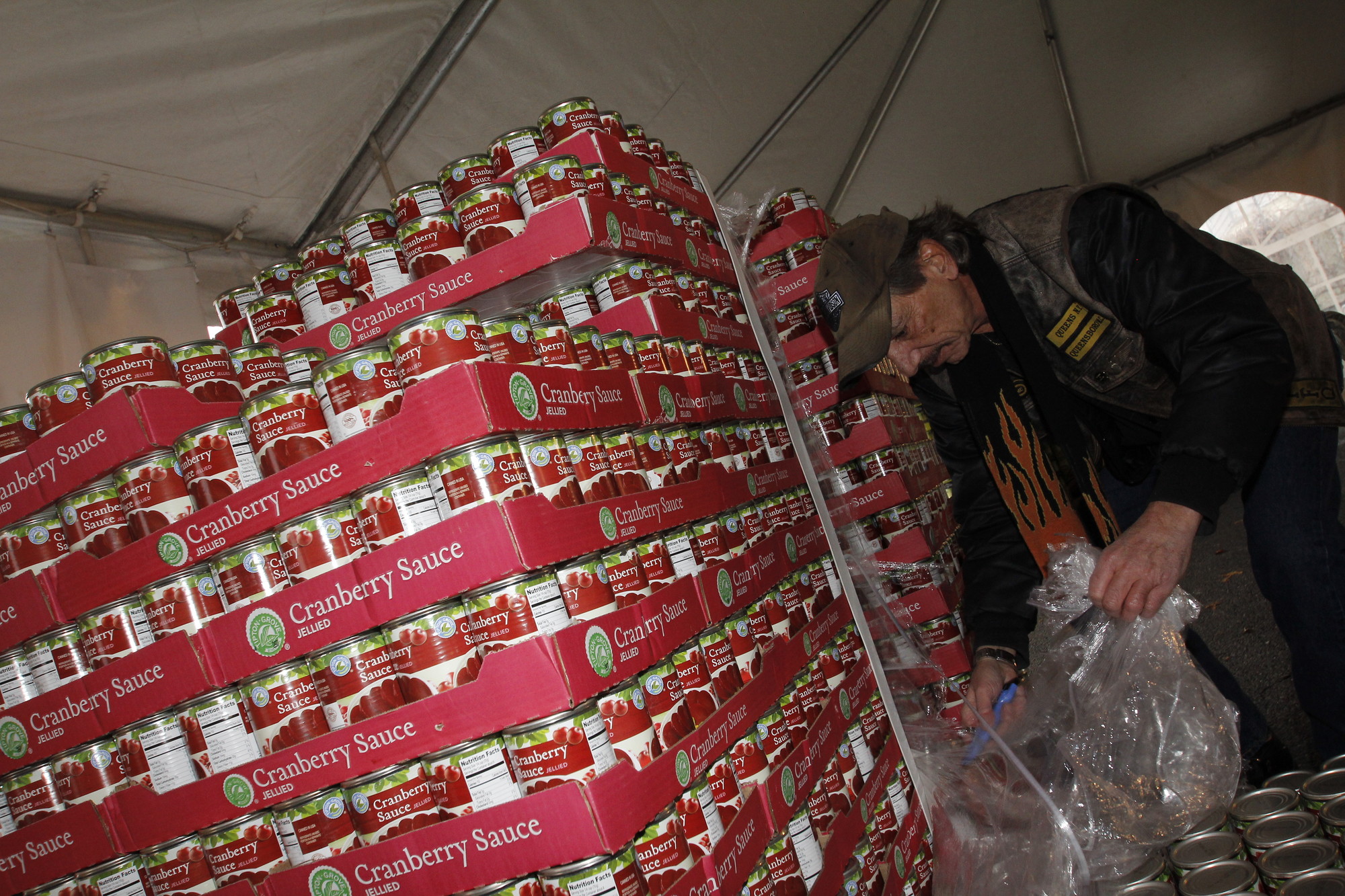 Steve Bibicoff from the QBMC, Queensboro Motorcycle Club, helps unpack a flat of Cranberry Sauce.