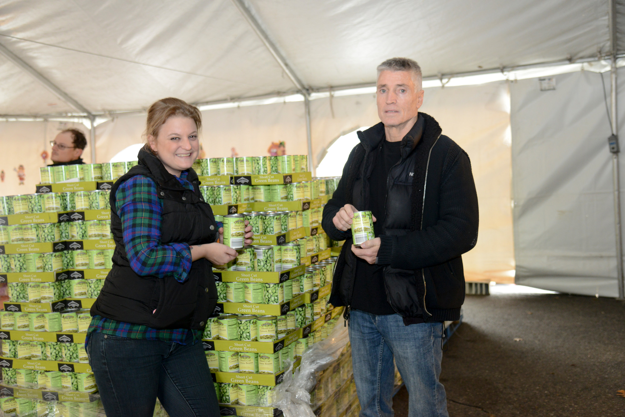At left, Mid-Island Employee Nicole Tirino Wilke and organizer Robert Jesberger with just one of the many pallets of food he purchased.