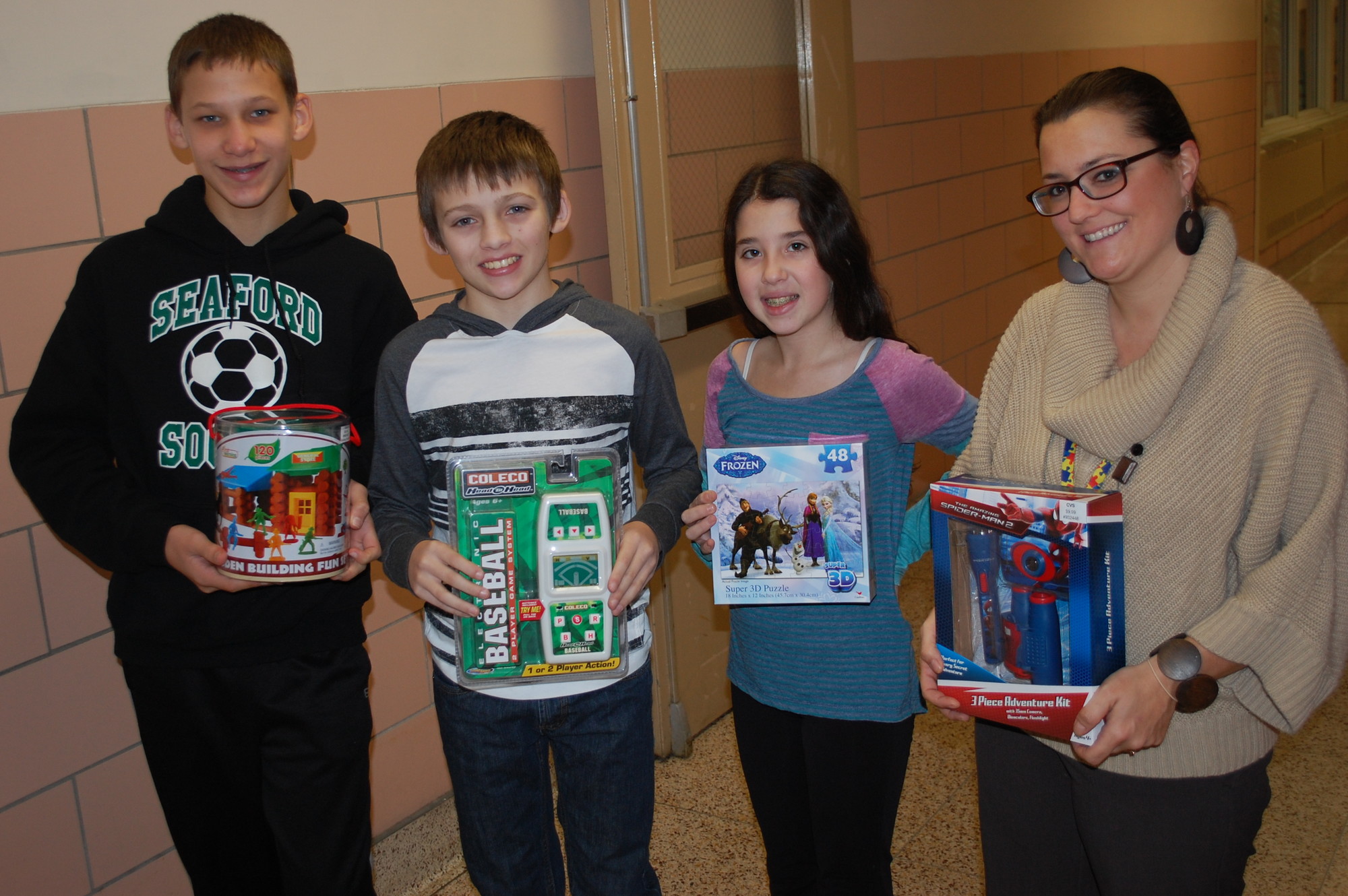 Middle School Student Council members, from left, Eric Schneider, Liam McDonald, Hailey Galison and adviser Angela McGibney with some of the toys that have already been donated.