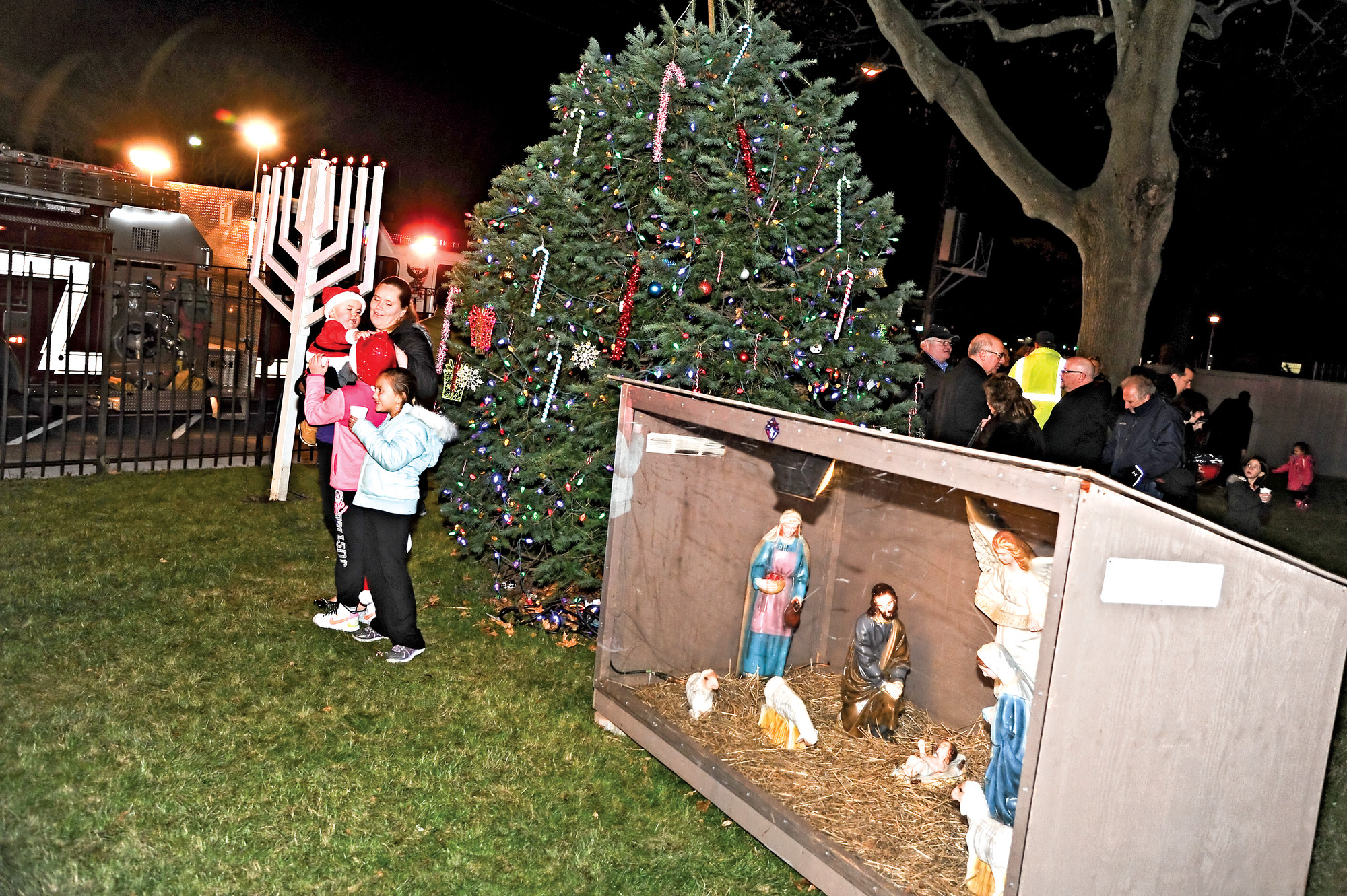 Residents posed in front of the Christmas tree, menorah, and the crèche depicting the birth of Christ.