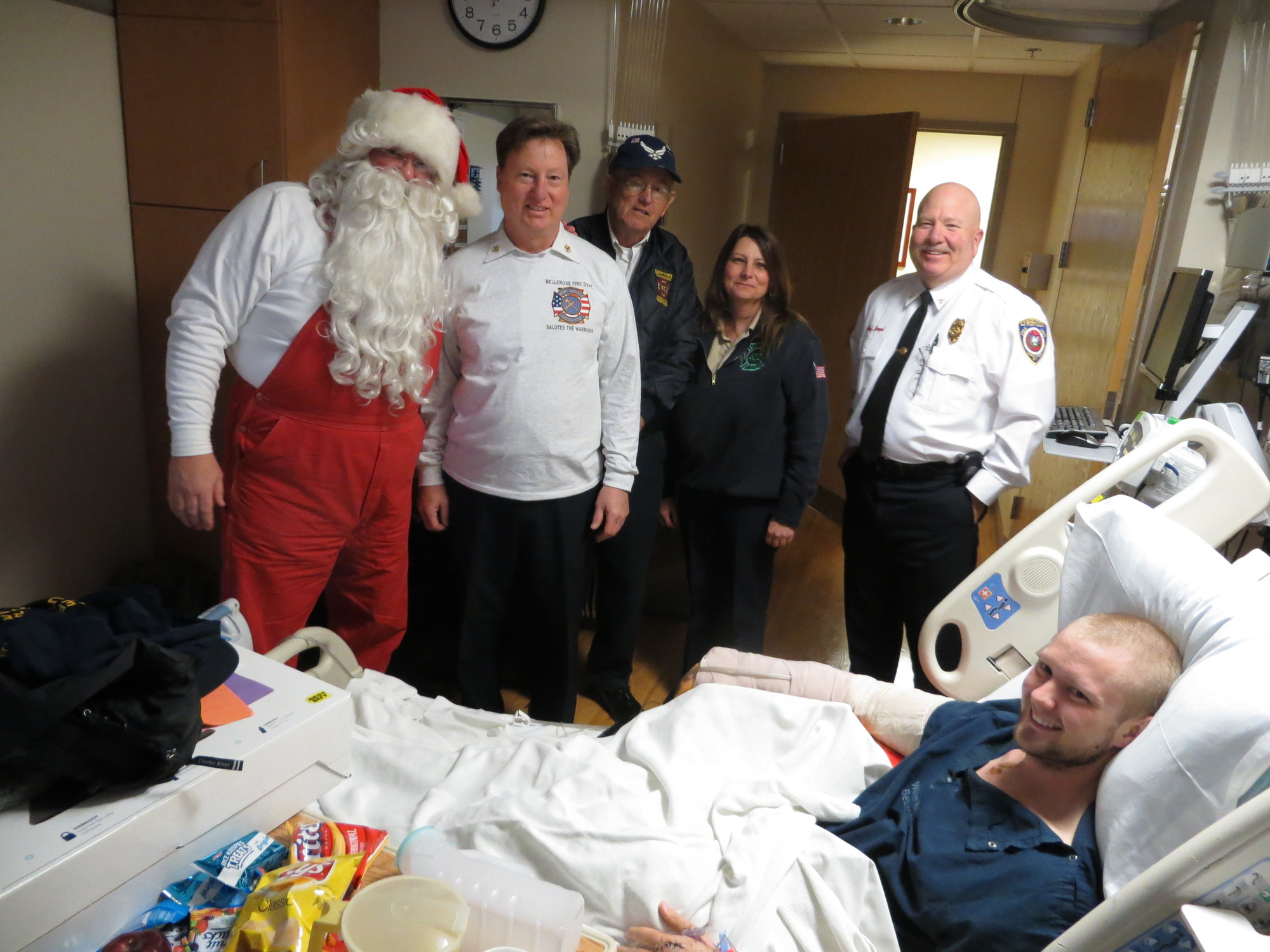 A happy Christmas SEAL:
On Dec. 5, a wounded Navy SEAL hospitalized at the Walter Reed National Military Medical Center in Bethesda, MD, welcomed a few special vistors bearing gifts — including a new laptop computer. At his bedside were, from left, Santa Claus (Terrence Powderly) and John Cortapasso, from the Bellerose Fire Department, and Lynbrook Fire Department members Jack Callahan, Lynn Donnelly and Chief Carl Lengel.