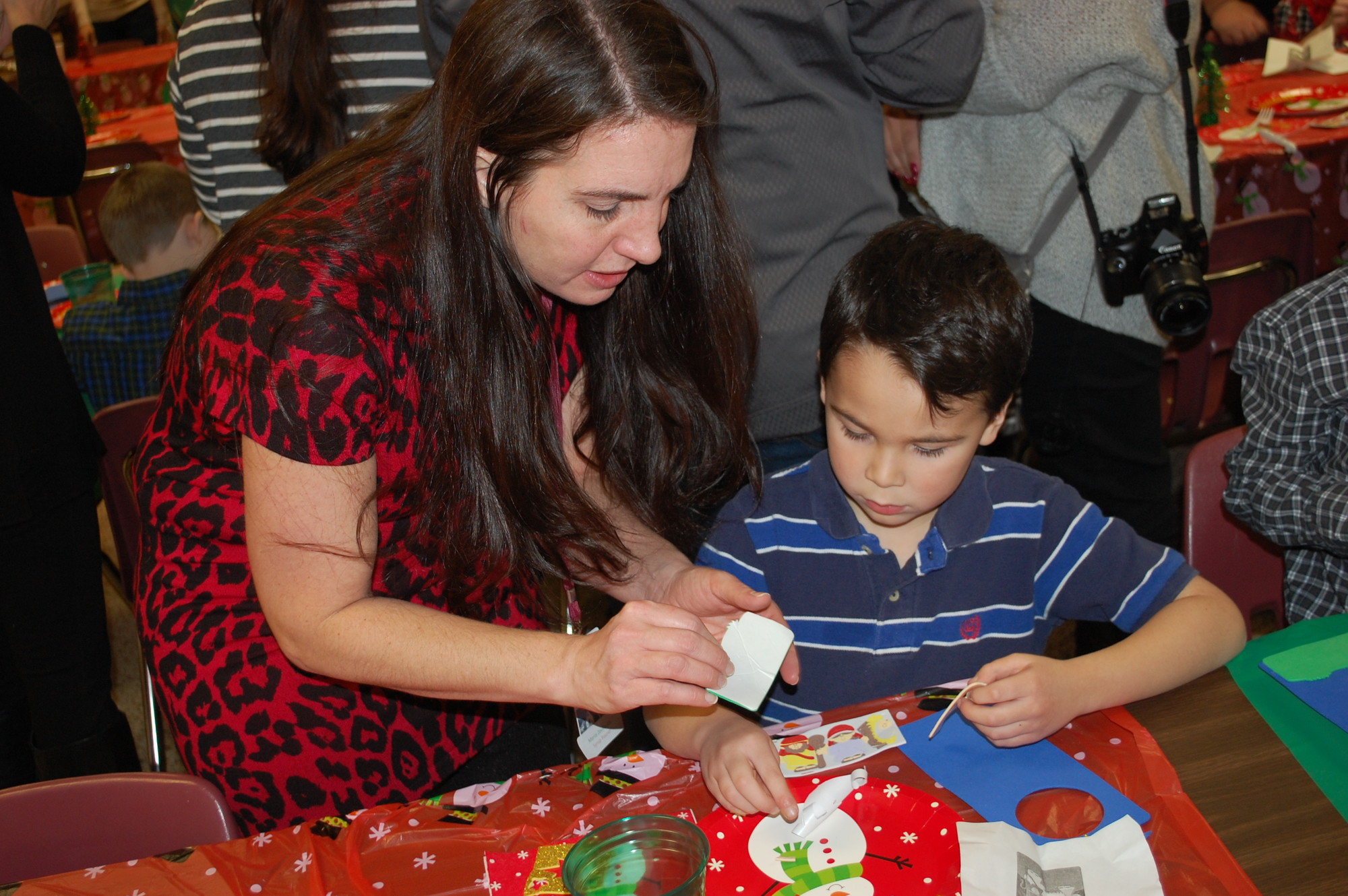 Parent volunteer Maria Zouloufis helped first-grader Evan Rojas with his craft.