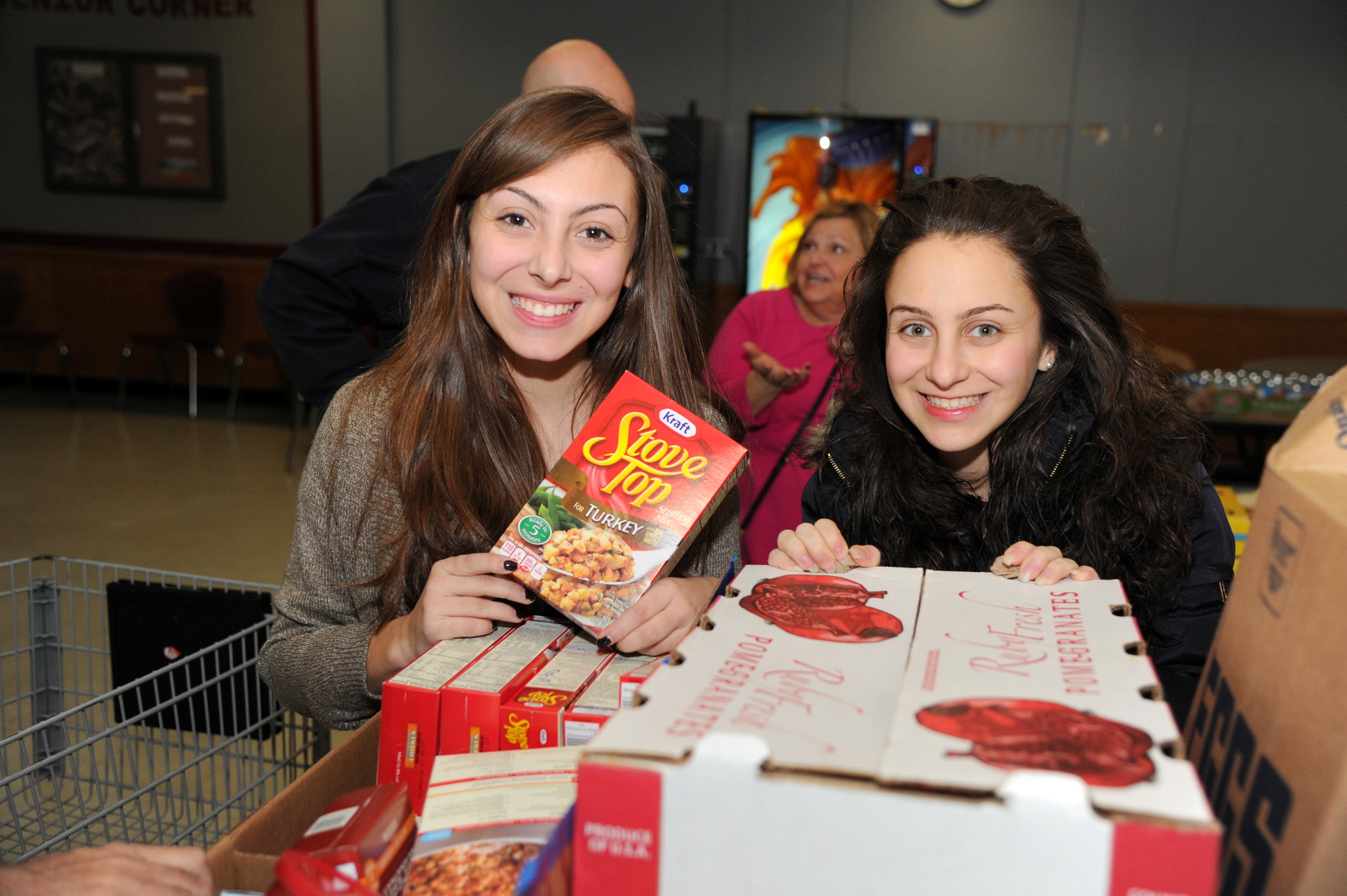 Sisters Gina and Christina Principato, both graduates of W.T. Clarke High School, returned to their old school last Friday to help the East Meadow Kiwanis Club sort food into bags, to be delivered the next morning by club members to 125 families in the local community who have fallen on hard times.