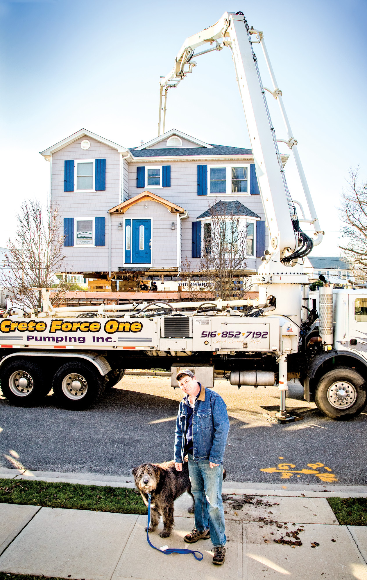 Reilly and his dog, Marley, in front of his home, which is in the process of being elevated.