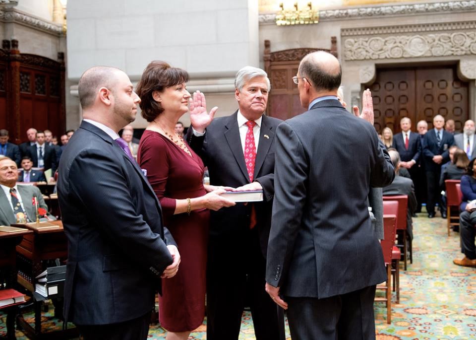 Senator Dean Skelos, center, second from right, was given his oath of office by his brother, Judge Peter Skelos, right. He was joined by his wife, Gail, who held the Bible, and his son, Adam.