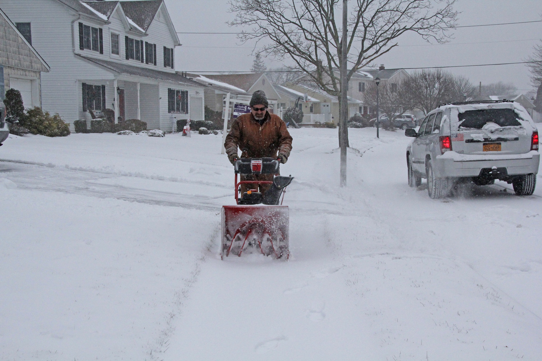 Sean Bates cleared the snow from the front of a home on Paddock Avenue in Seaford.