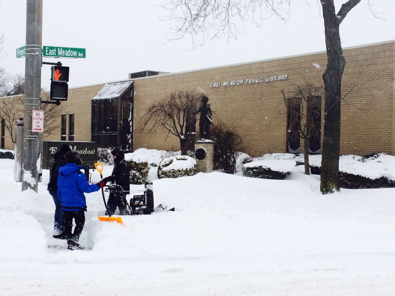 Shovelers dug out snow in front of the East Meadow Public Library.