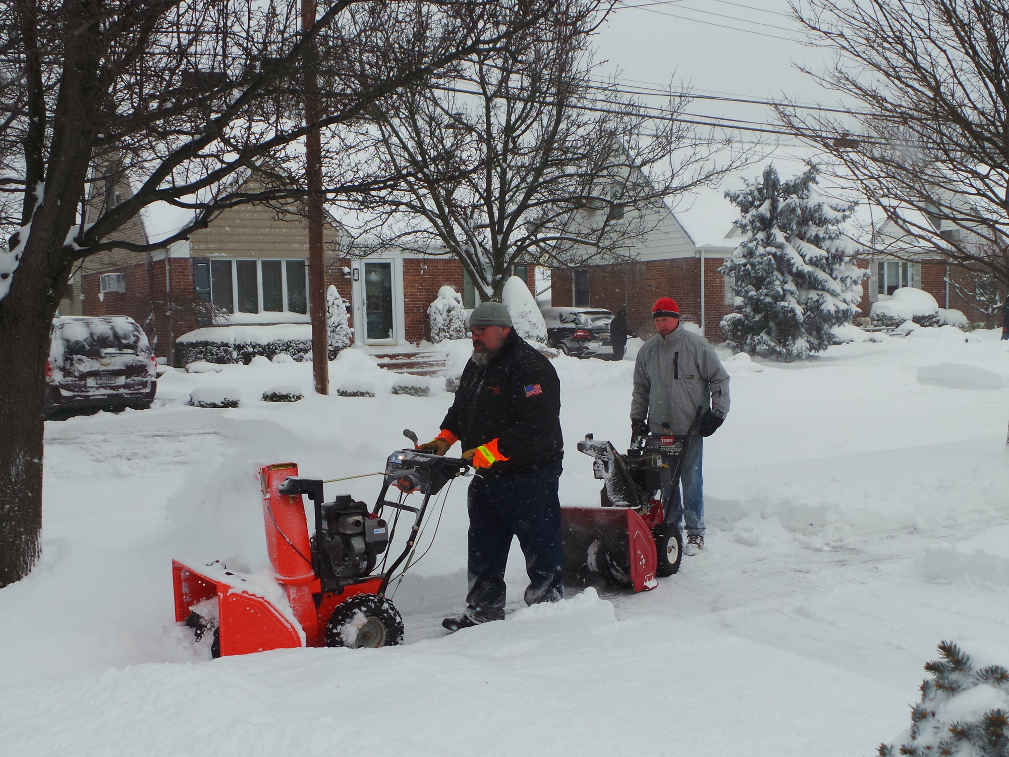 Andrew Chernoff, left, and John Flynn, double team a snowblowing effort to help their neighbors dig out from under 14" of snow.