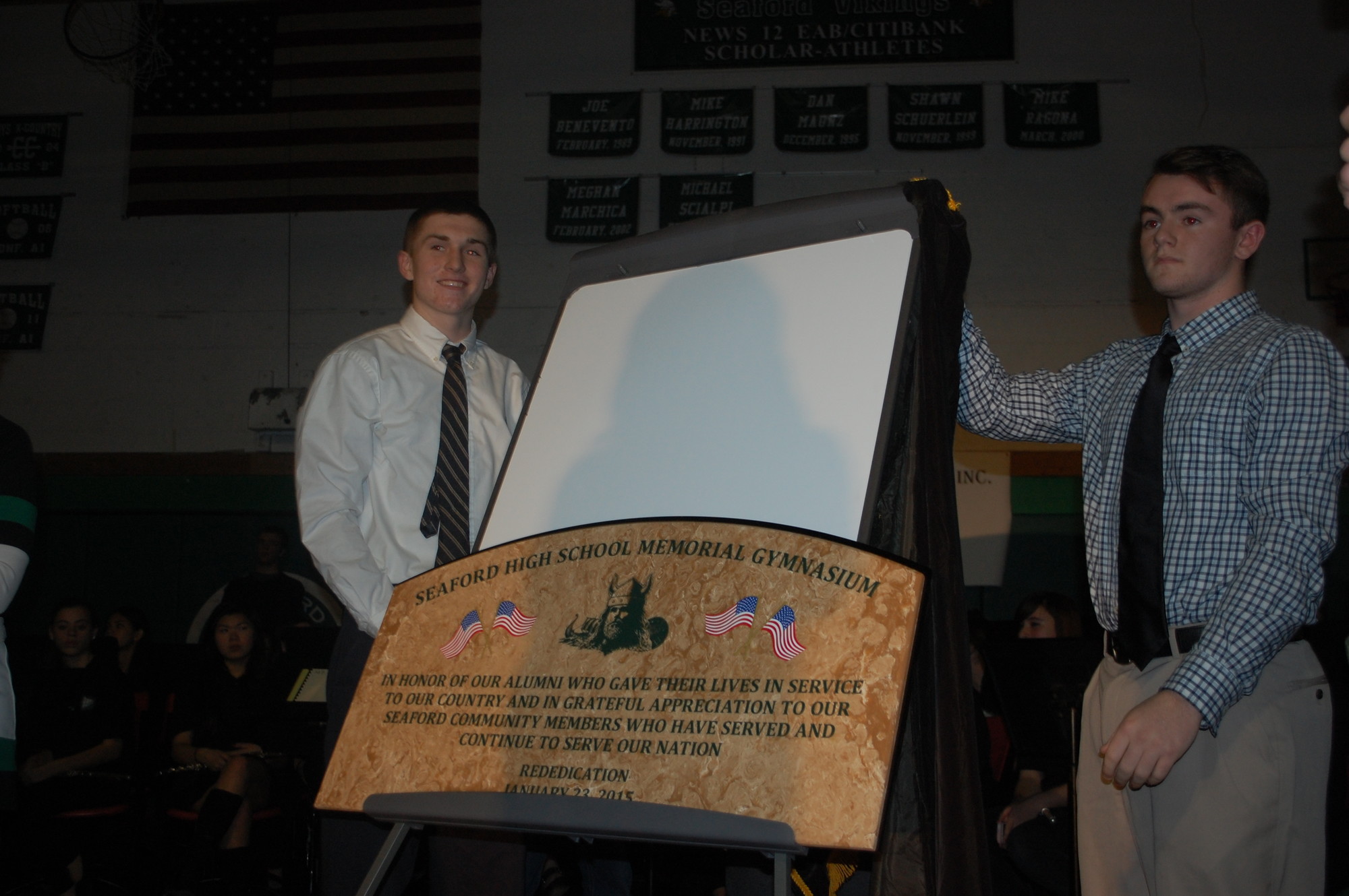 Seaford High School seniors Bobby Buell, left, and Jake Doyle unveiled the new dedication plaque that will hang above the entrance to Memorial Gymnasium.