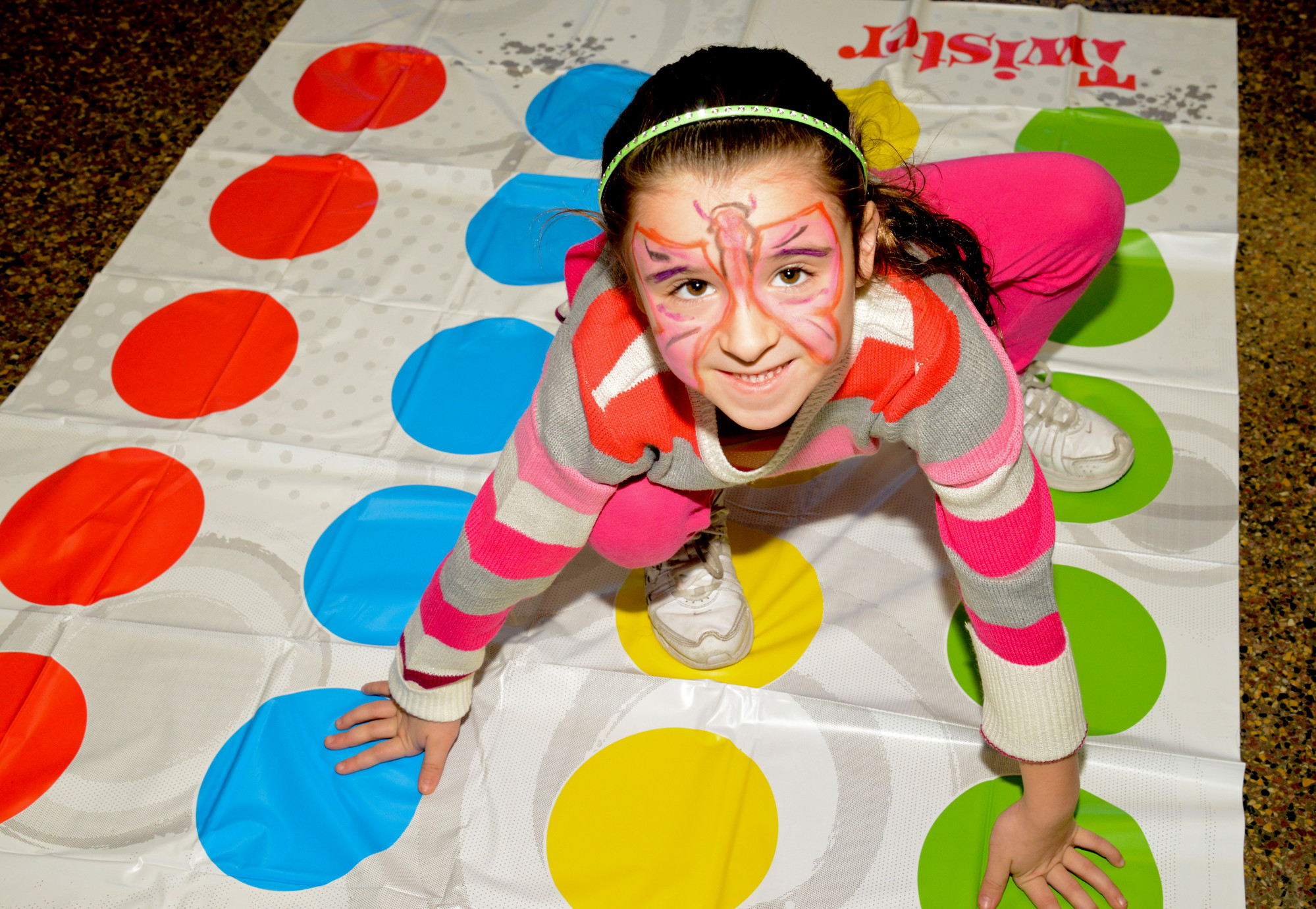 Briana, 5, had a blast on the Twister mat shortly after getting a butterfly painted on her face.